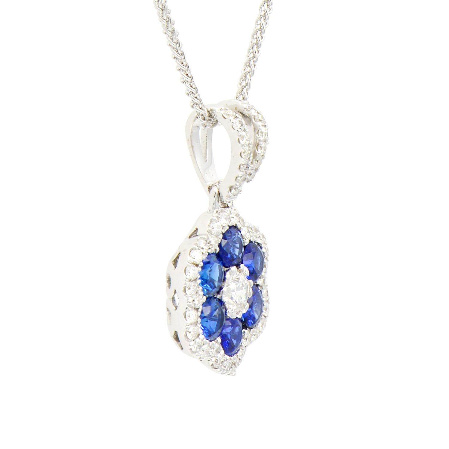 This beautiful pendant is made from 1.8 grams of 18 karat white gold. The flower shape is made from 6 blue sapphires totalling 0.6 carats with VS2, G color diamonds for the center and as a halo around the sapphires as well as on the bail of the