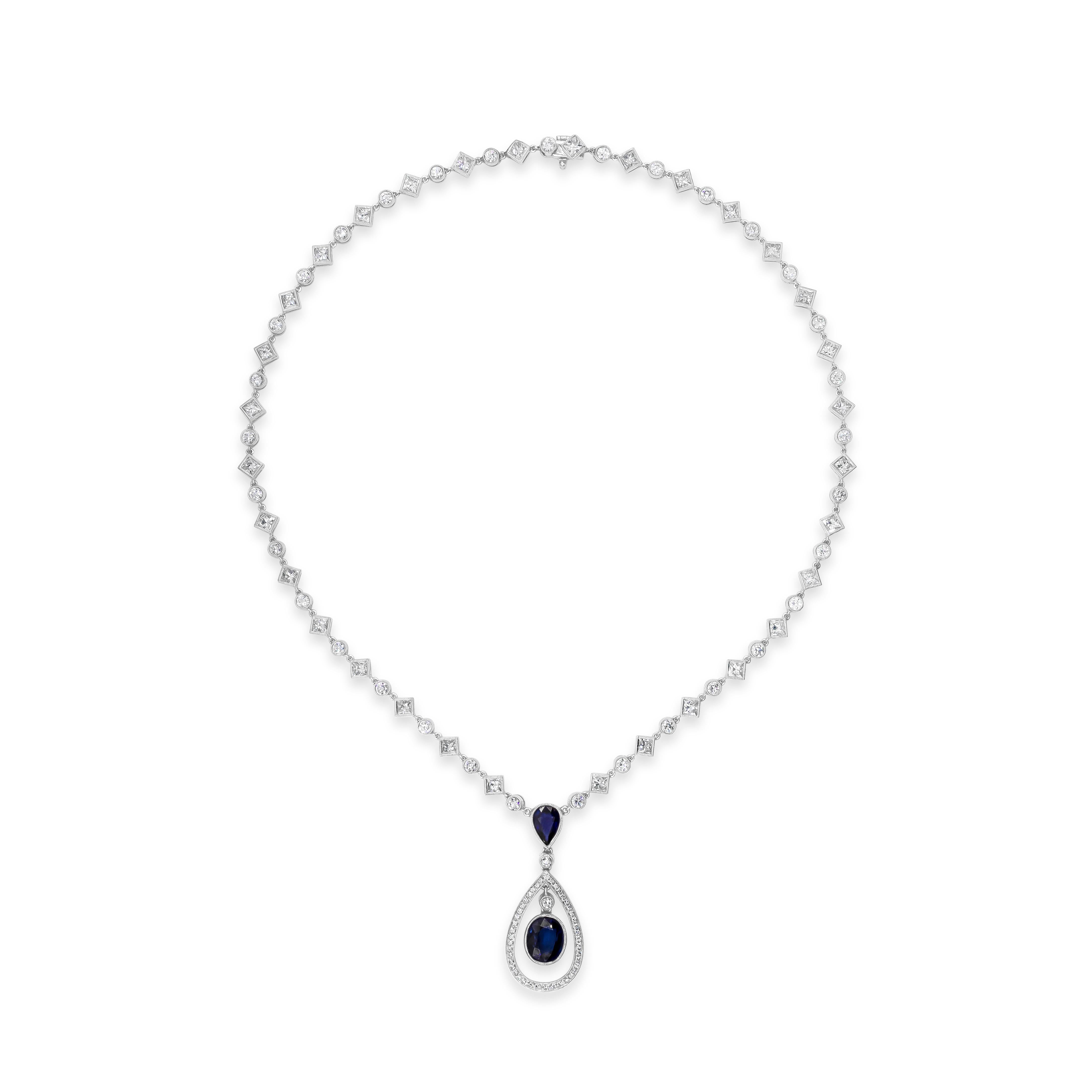 This beautiful and finely crafted halo drop design necklace features an oval and pear shape blue sapphires weighing 4.29 carats total, suspended on a vintage style diamond by yard chain. Elegantly alternating princess cut and round diamonds weighing