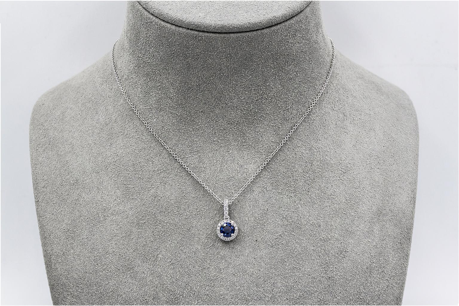 A color-rich pendant necklace showcasing a 0.72 carat blue sapphire, surrounded by a single row of round brilliant diamonds weighing 0.19 carats total. Suspended in an 18 inch white gold chain (adjustable upon request). 

Style available in