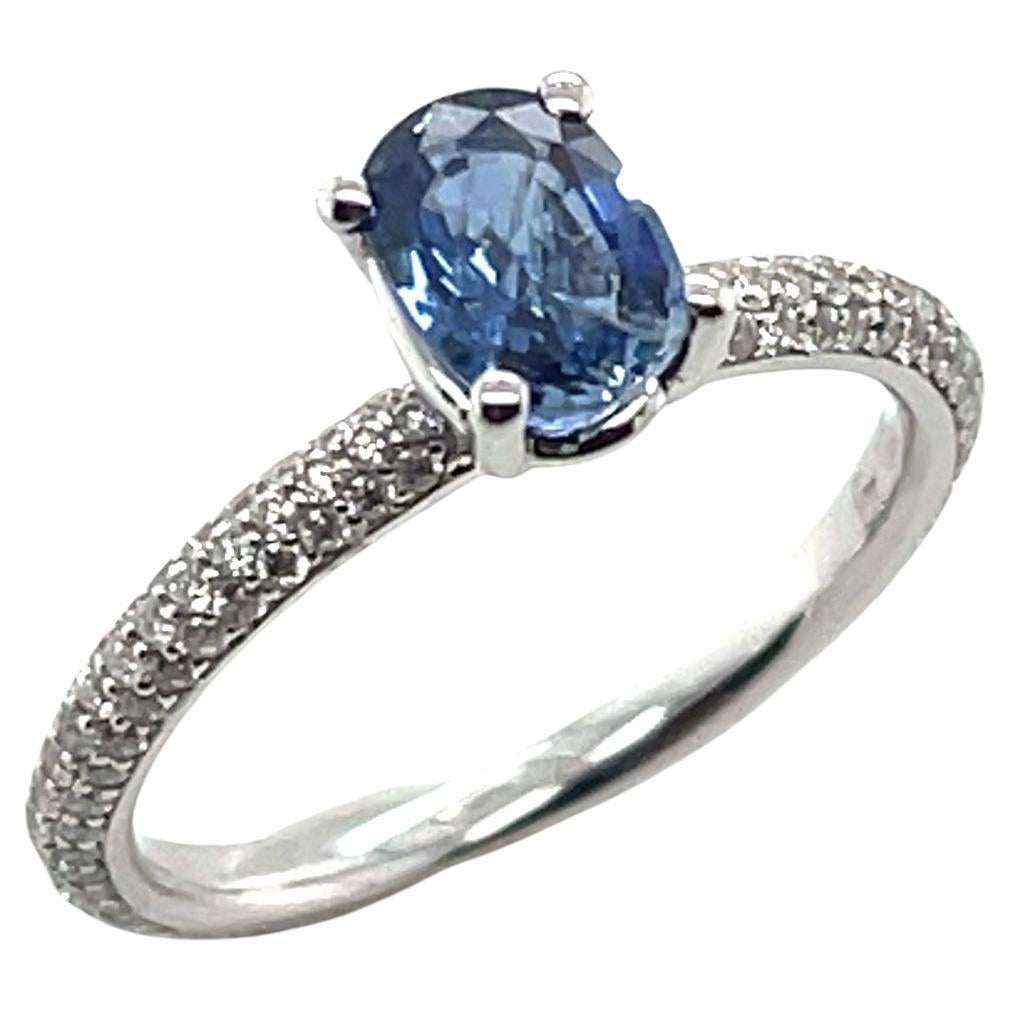 This dazzling blue sapphire and diamond ring features a .98 carat, sparkling blue sapphire set against 135 brilliant white diamonds that have been pave set into an elegant 18k white gold band. Diamonds provide the perfect backdrop for this petite