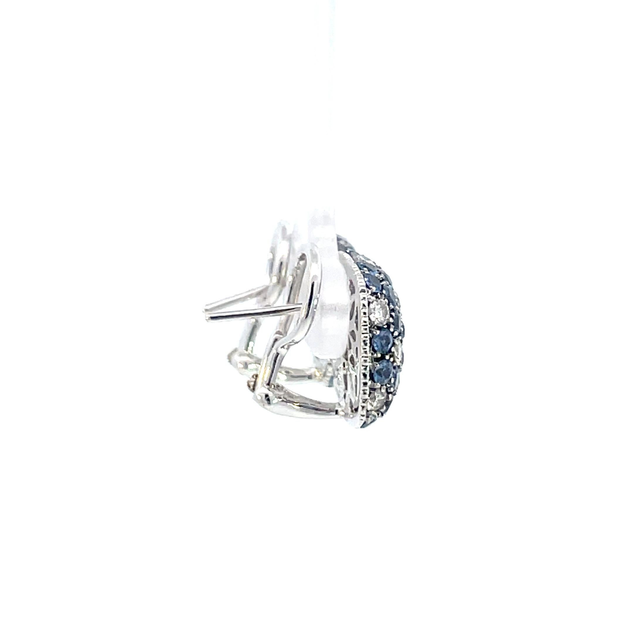A pair of cushion shaped earring set with natural blue sapphires and brilliant cut diamonds in 18kt white gold with hand cut coin edge finish and a beautiful open designed gallery, straight post and omega clip system. 

64 natural blue sapphires