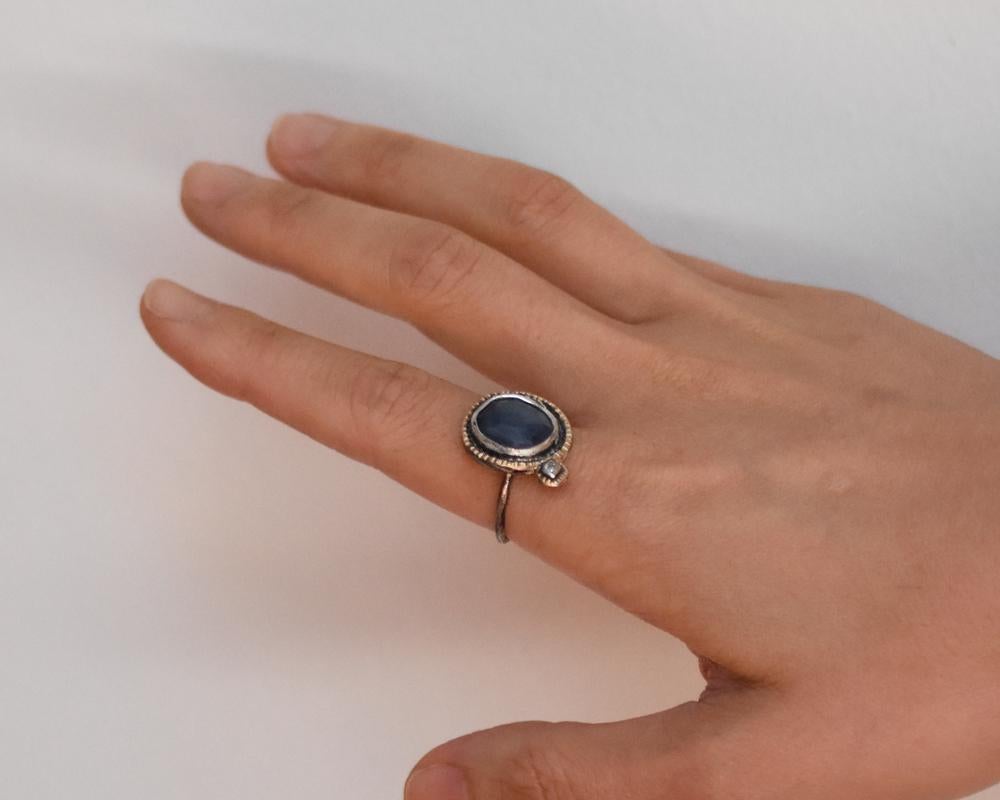 This one-of-a-kind oxidized sterling silver and 14k gold ring features a beautiful large blue sapphire with an offset diamond. Paying homage to tradition, the ring has been formed from scratch using heirloom tools from Franny's Father and