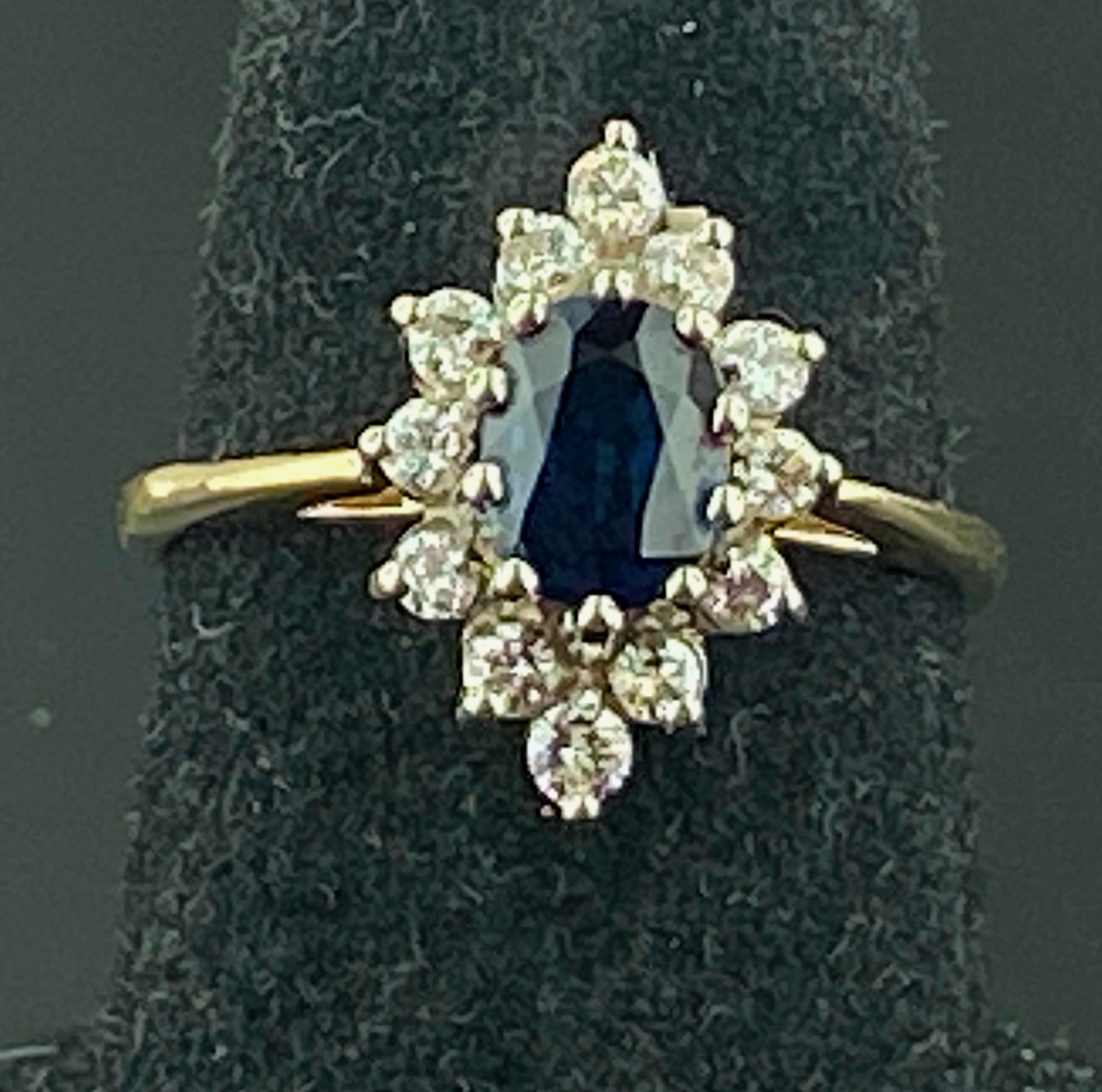 Set in 14 karat yellow gold is a 1.00 carat Oval cut Blue Sapphire with 12 round brilliant cut diamonds in a marquise shape around the sapphire weighing 0.30 carats.  Color: G-H, Clarity: SI-1.  Ring size is 7.5.