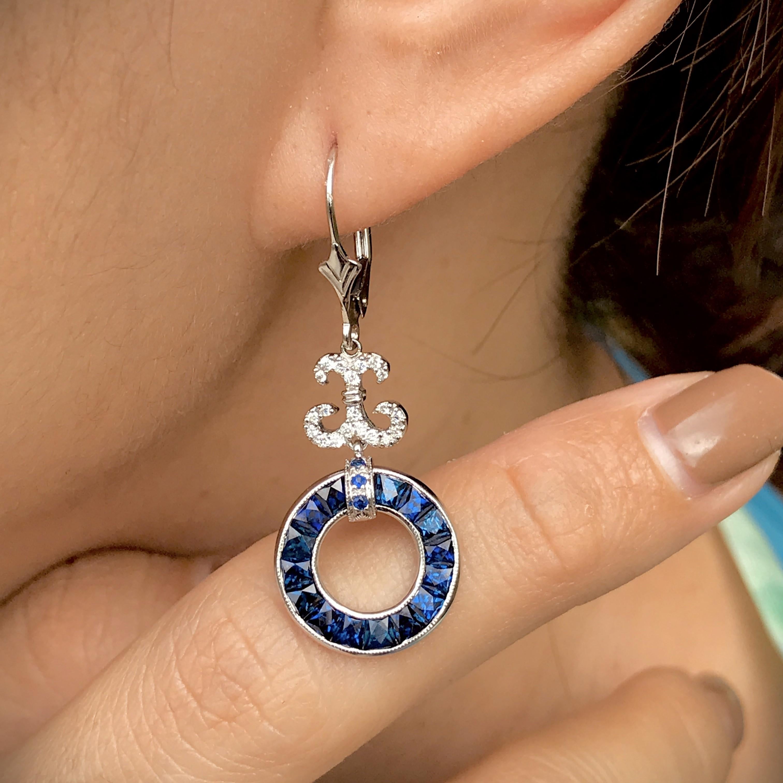A pair of Art Deco style sapphire and diamond drop earrings, set with round French cut sapphire open circle suspended from a row of round diamond. A really useful everyday ear stud that you will fall in love with. 

Information
Style: Art