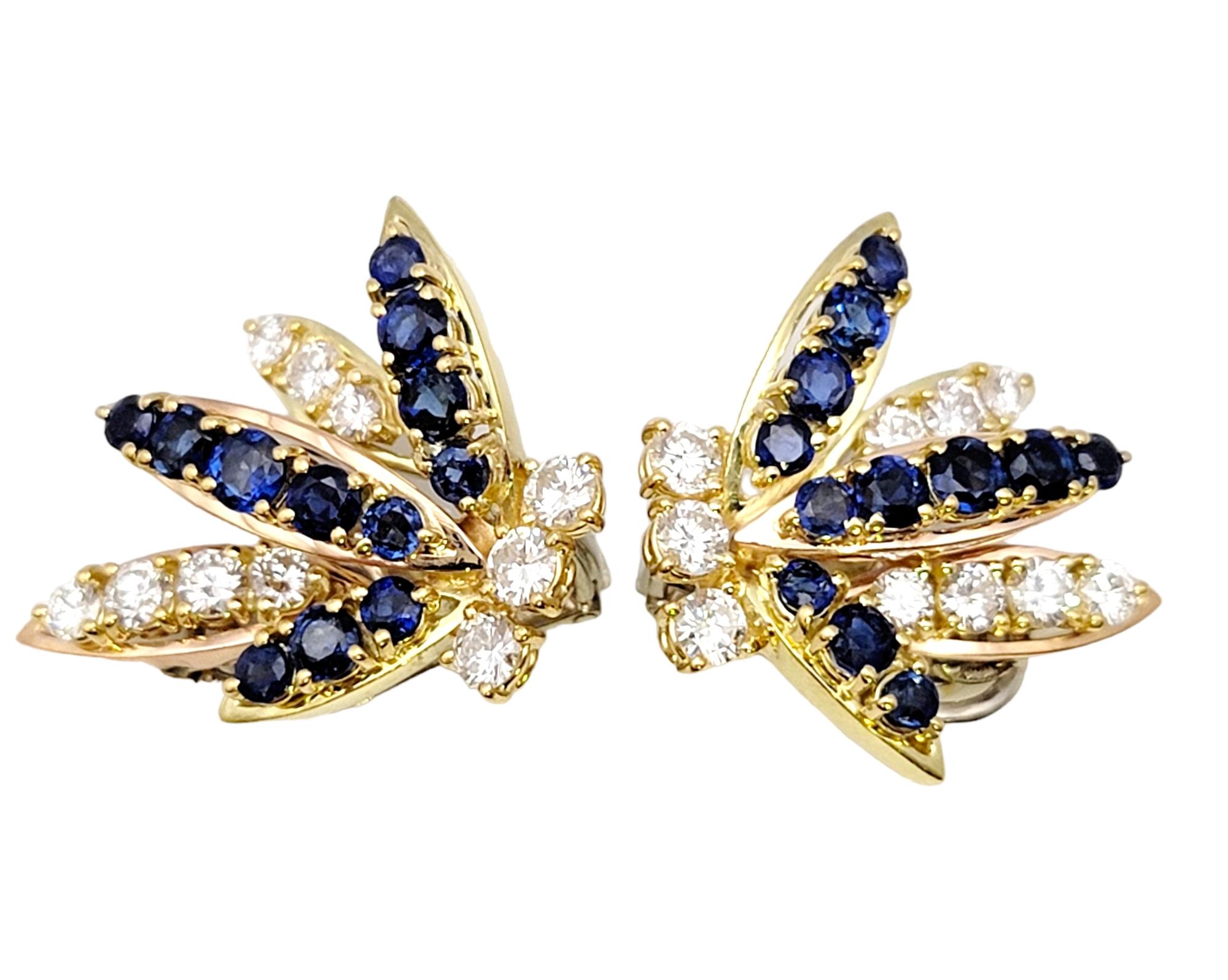 Absolutely breathtaking diamond and sapphire earrings. This exquisite pair features icy white diamonds and bright blue sapphires bursting off the lobe in a stunning spray design. The light reflects magnificently off the gemstones, making them