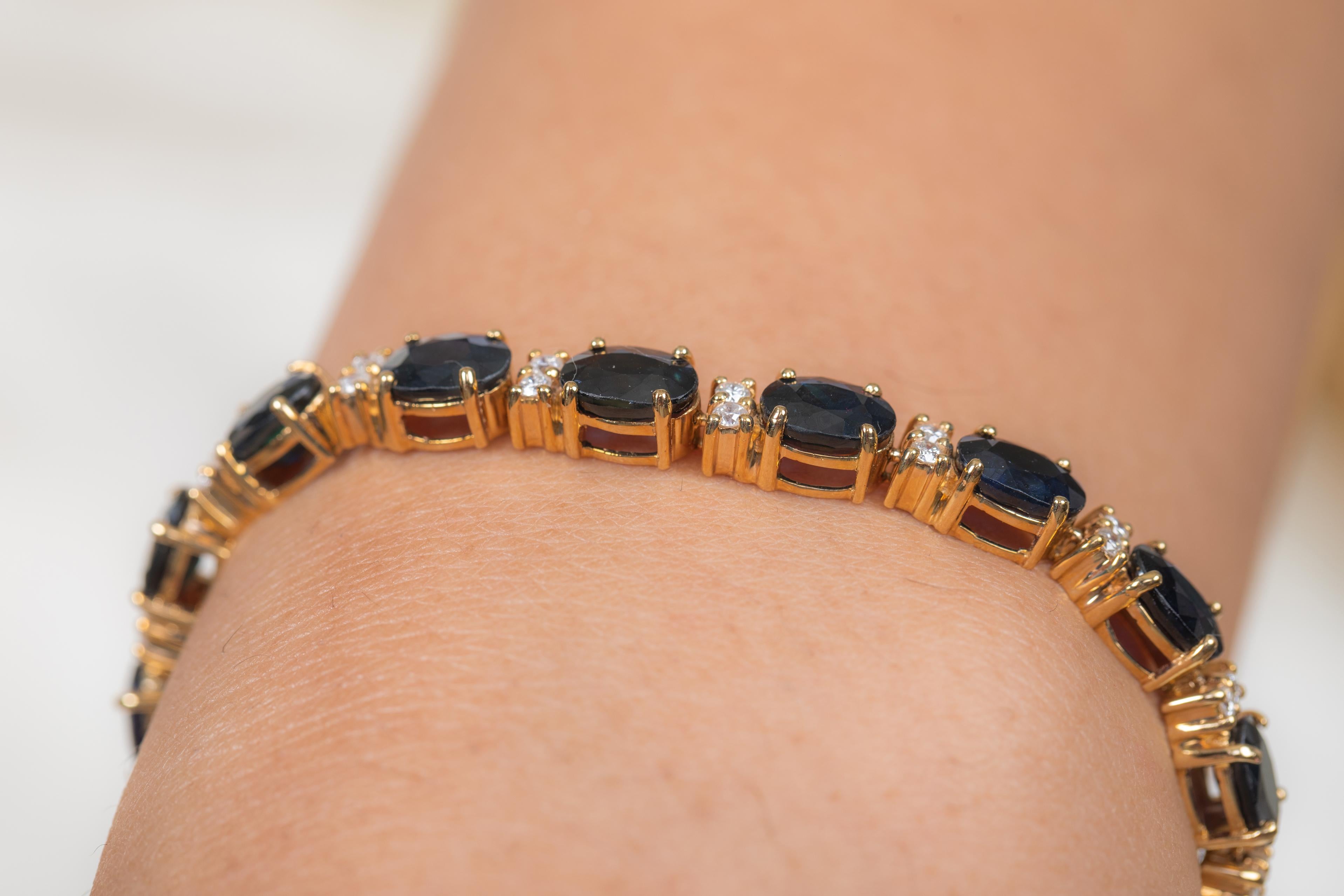 This Deep Blue Sapphire and Diamond Tennis Bracelet in 14K gold showcases sparkling natural blue sapphire weighing 18.52 carats and diamonds, weighing 0.75 carats. 
Sapphire stimulate concentration and reduces stress.
Designed with oval cut sapphire