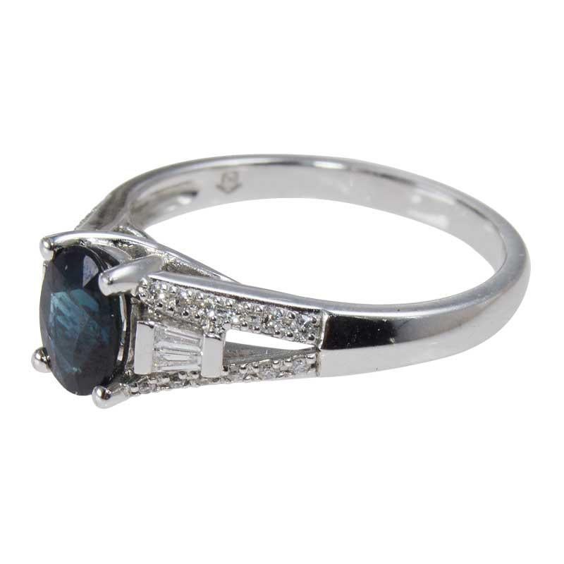
METAL / MATERIAL: 14Kt white gold
CIRCA / YEAR: Contemporary
STONES / WEIGHT: Blue Sapphire 0.80ct Oval Cut  
Round and Baguette Diamonds 0.25cts Total Weight G/H clarity VS/SI1 Clarity
RING SIZE: 7

Indigo Blue Sapphire, faceted in an oval shape