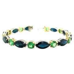 Blue Sapphire and Tsavorite Garnet Tennis Bracelet in White and Yellow Gold