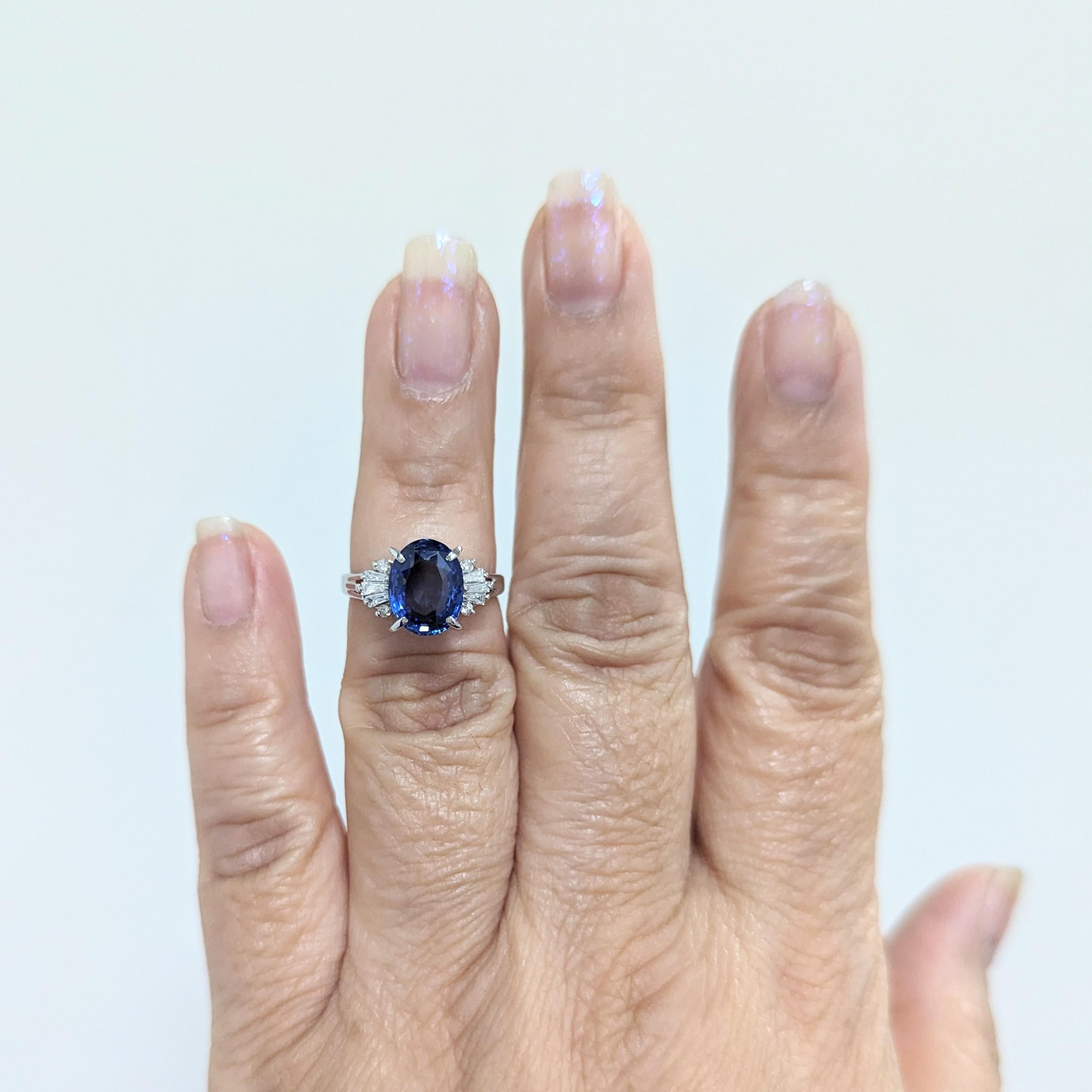 Magnifique saphir bleu ovale de 3,66 ct. avec des baguettes de diamants blancs de bonne qualité de 0,20 ct.  Fait à la main en platine.  Bague taille 6.5.