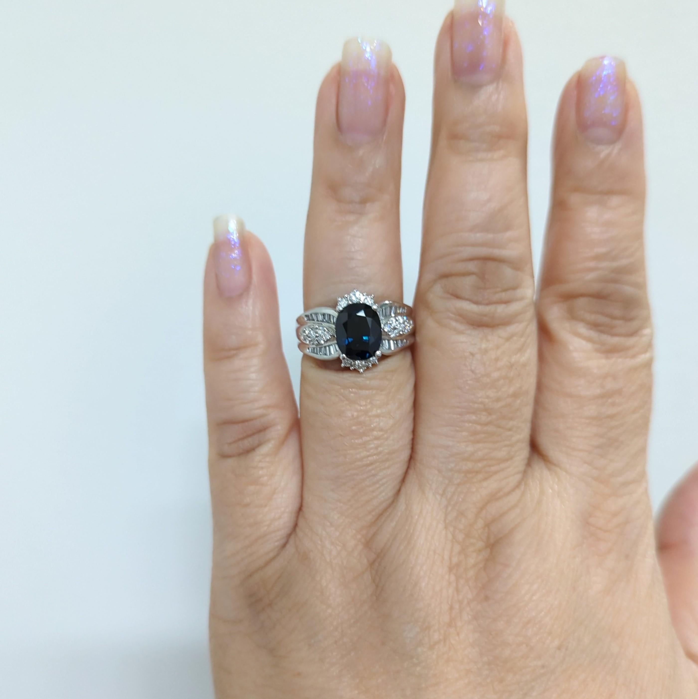 Magnifique saphir bleu ovale de 3,21 ct. avec 0,80 ct. de diamants blancs ronds et baguettes de bonne qualité.  Fait à la main en platine.  Bague taille 7.  