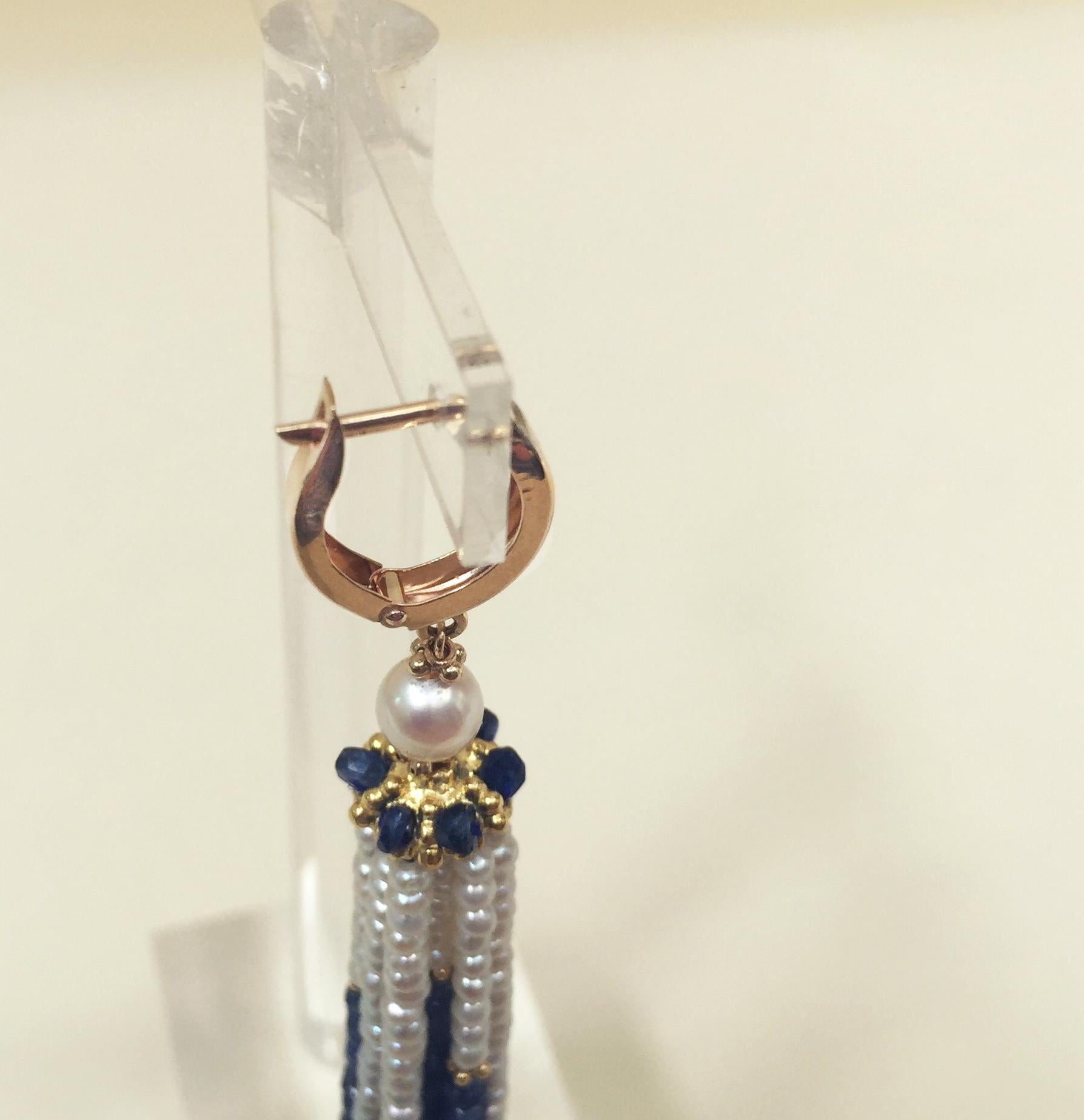 These striking blue sapphire and white pearl tassel earrings with 14k yellow gold lever backs are beautiful for the color combination of deep blue, glowing white, and bright yellow gold tones. A small 5 mm round pearl hangs from the 14k yellow gold