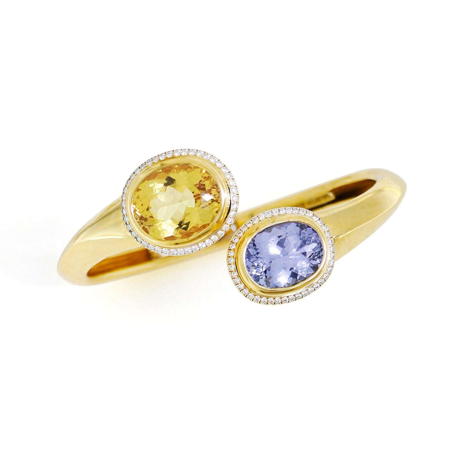 Delicati zaffiri e berilli gialli si uniscono in questo bracciale in oro giallo 18 carati. Un cuscino di berillo giallo si trova a un'estremità, mentre l'altra sostiene un cuscino di zaffiro. Entrambe le forme ovali sprigionano un vivido scintillio