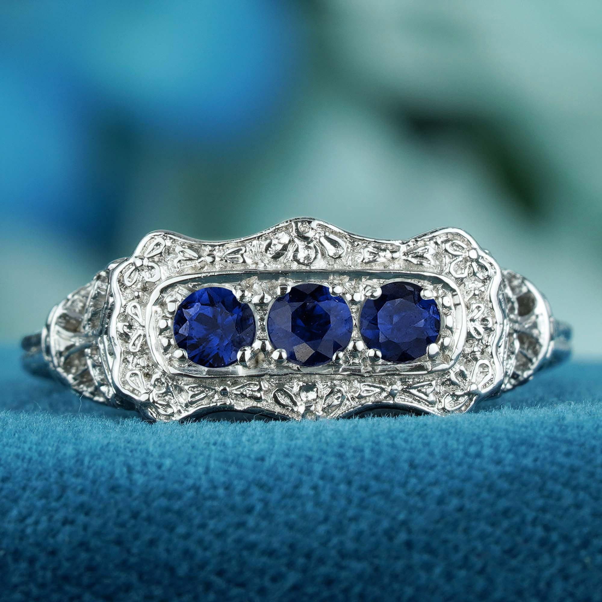 Une élégance classique avec une touche moderne Cette bague à trois pierres en or blanc 9 carats, de style Art déco et ornée d'un saphir bleu naturel, est une fusion parfaite entre le charme vintage et le luxe contemporain. Les saphirs d'un bleu