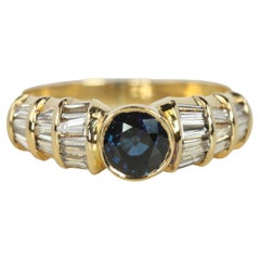 Anillo de compromiso de zafiro azul y diamante baguette en oro amarillo de 18 quilates