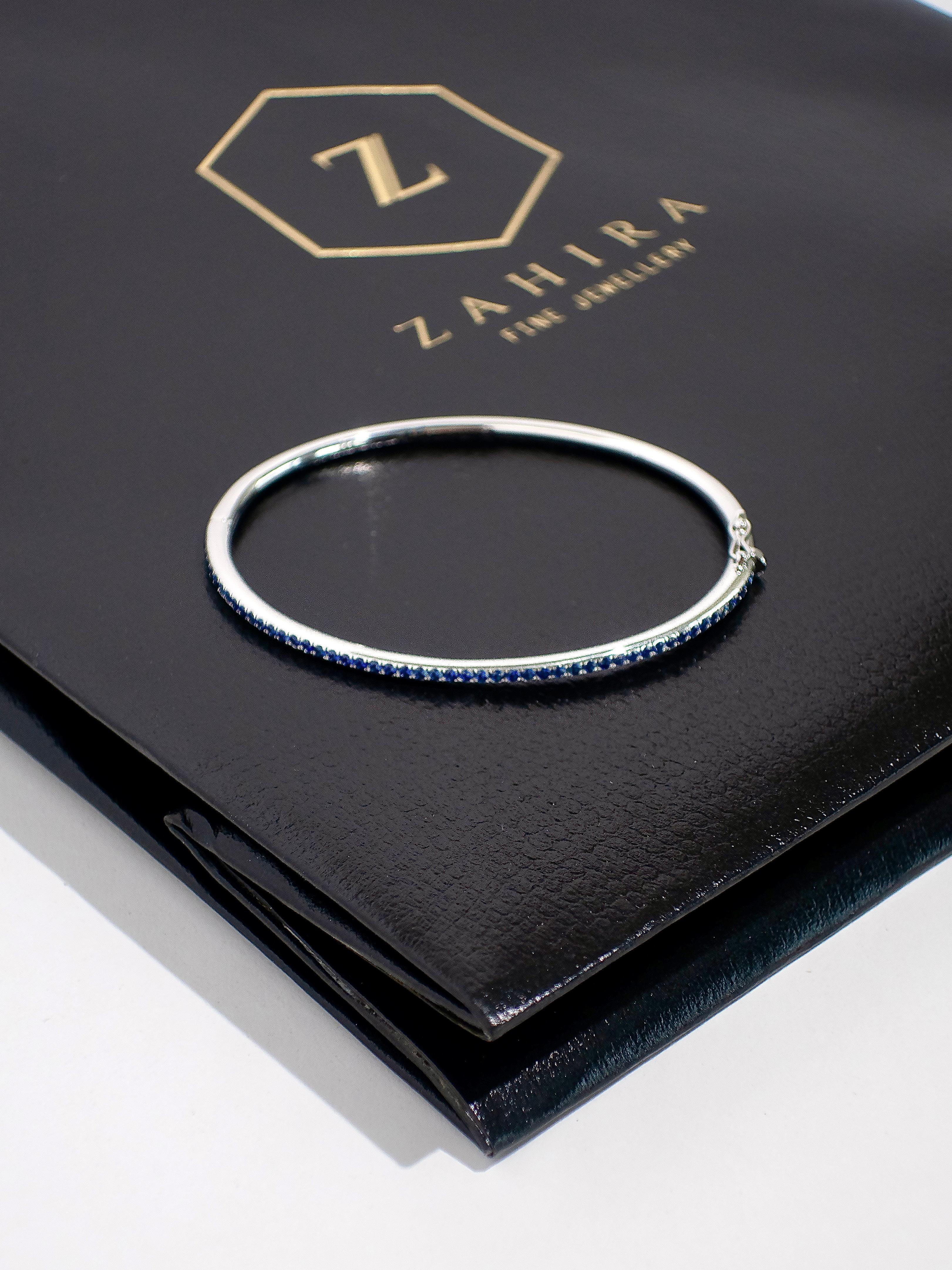 This stunning 18K white gold bangle is a statement piece that effortlessly combines elegance with contemporary flair. Its sleek, oval shape ensures a perfect fit on the wrist, offering both comfort and style. The bangle is meticulously paved with