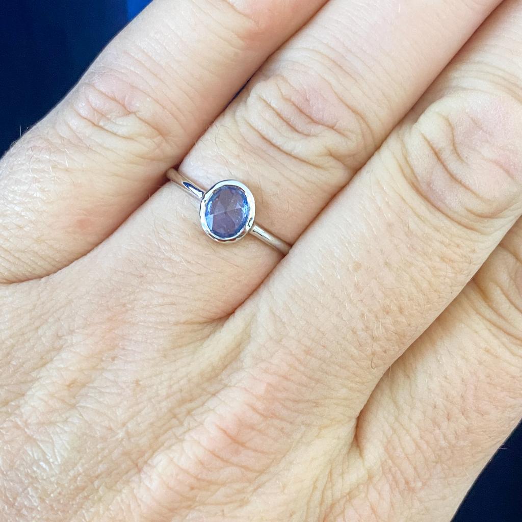 This sapphire ring has lovely smooth curves in a one-of-a-kind piece. The rose-cut oval sapphire is set in a custom bezel to fit its own unique shape. Any similar piece will never be exactly like it. This ring was handmade and is from Austin's
