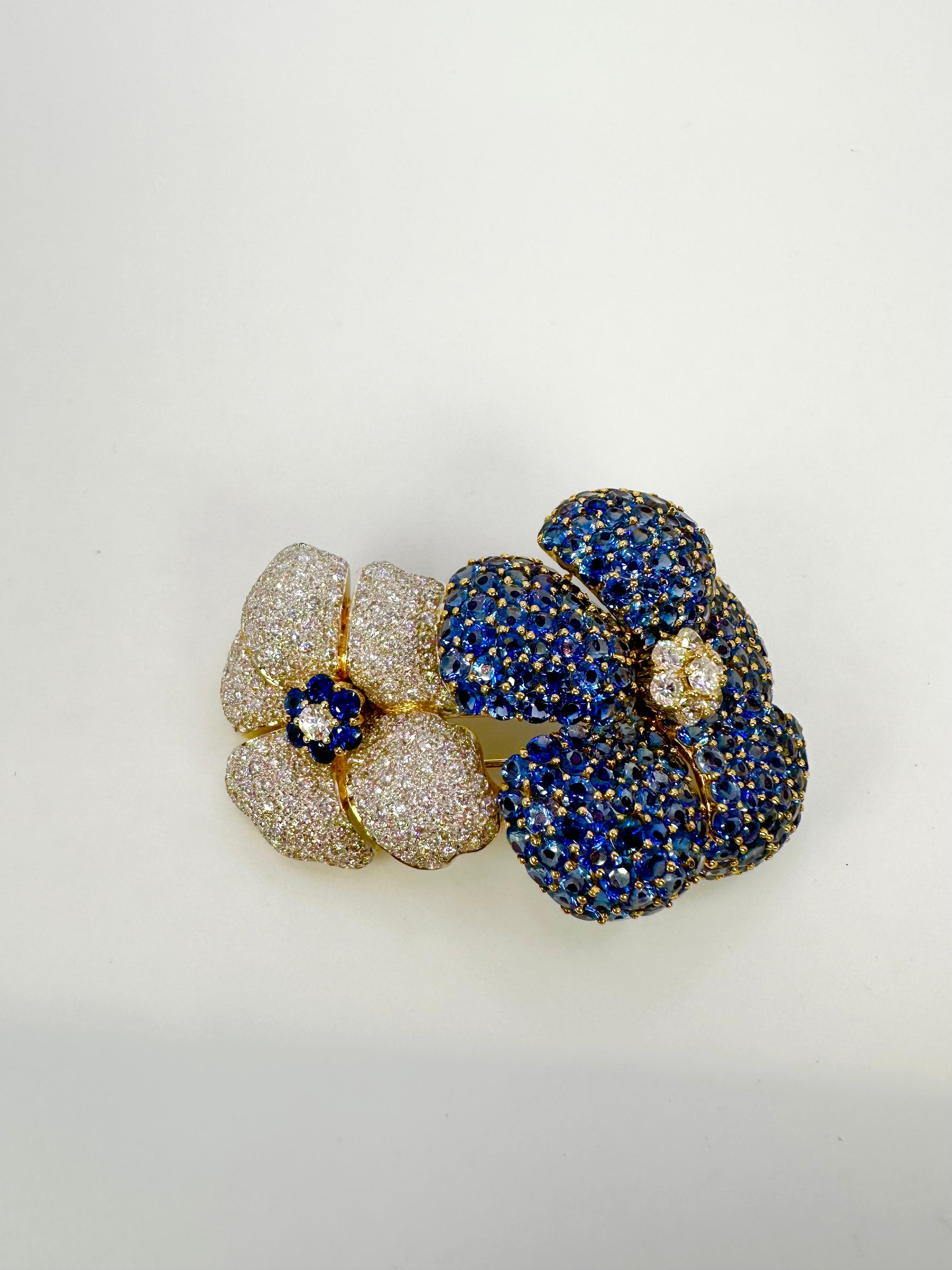 Luxurious flower brooch made with natural sapphires and diamonds in 18KT white gold. The rare setting style is called invisible setting and does not show any metal just stones. 

GRAM WEIGHT: 34.82gr
GOLD: 18KT yellow gold
SIZE: 2.30inches x 1.60