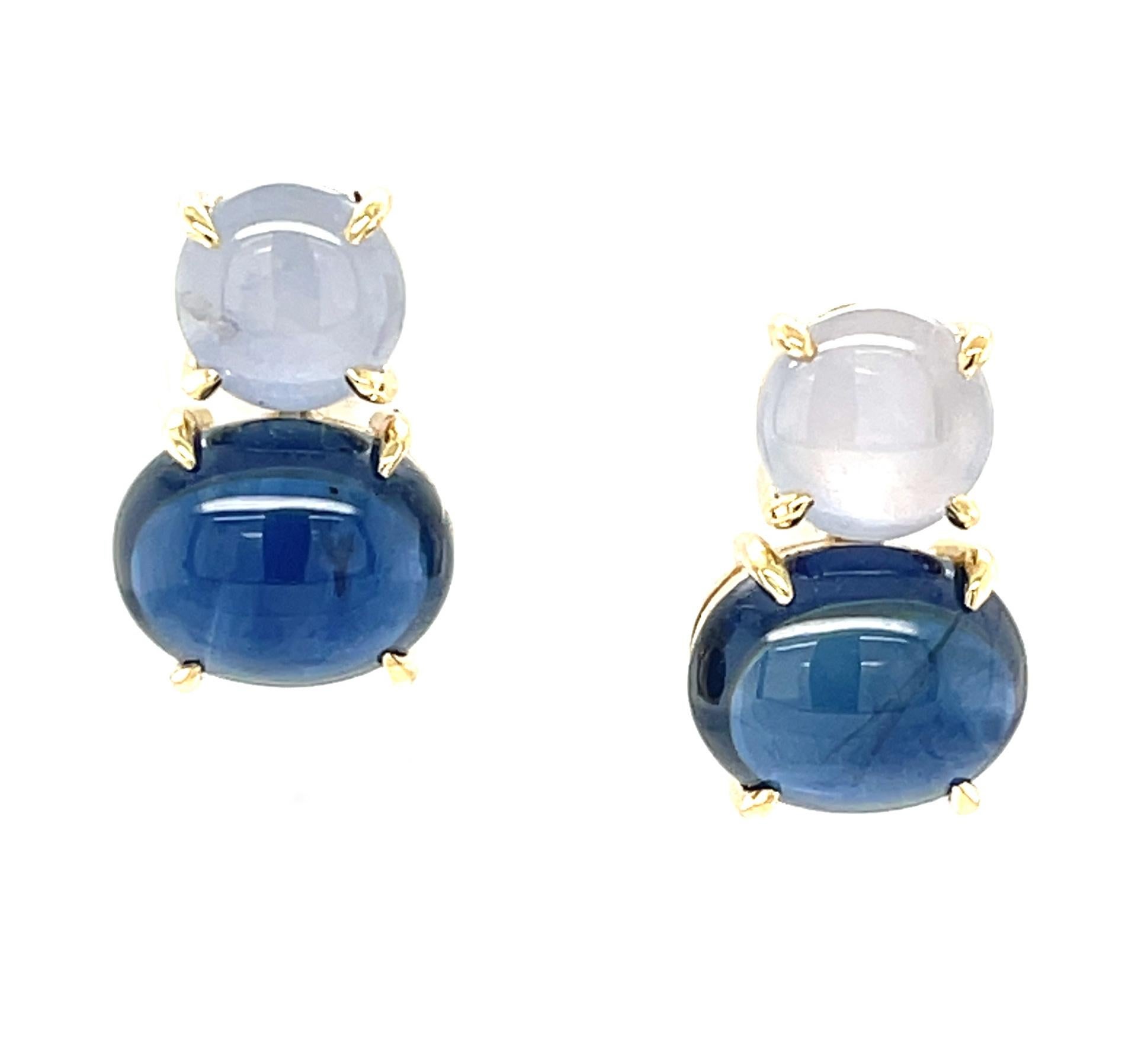 These striking earrings feature beautiful blue sapphire cabochons set in 18k yellow gold with silver star sapphires! Star sapphire exhibit a phenomenon called asterism, a visual effect that occurs as light reflects from natural 