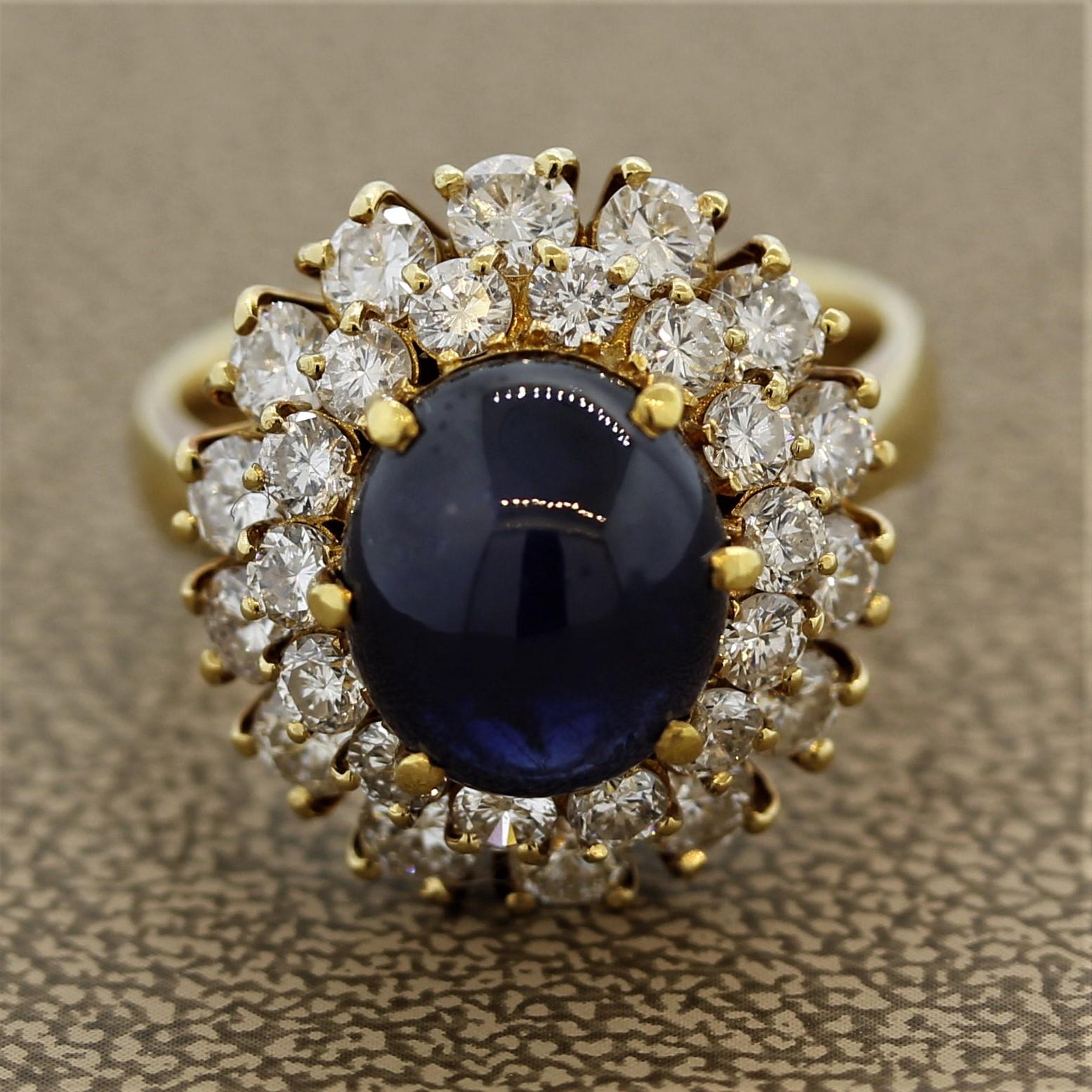 A lovely gem-set ring featuring a fine cabochon sapphire weighing 5.00 carats. It has a deep vivid blue color typical with fine stones from Burma (Myanmar). It is surrounded by a cluster of larger sizes round brilliant cut diamonds weighing 2.16