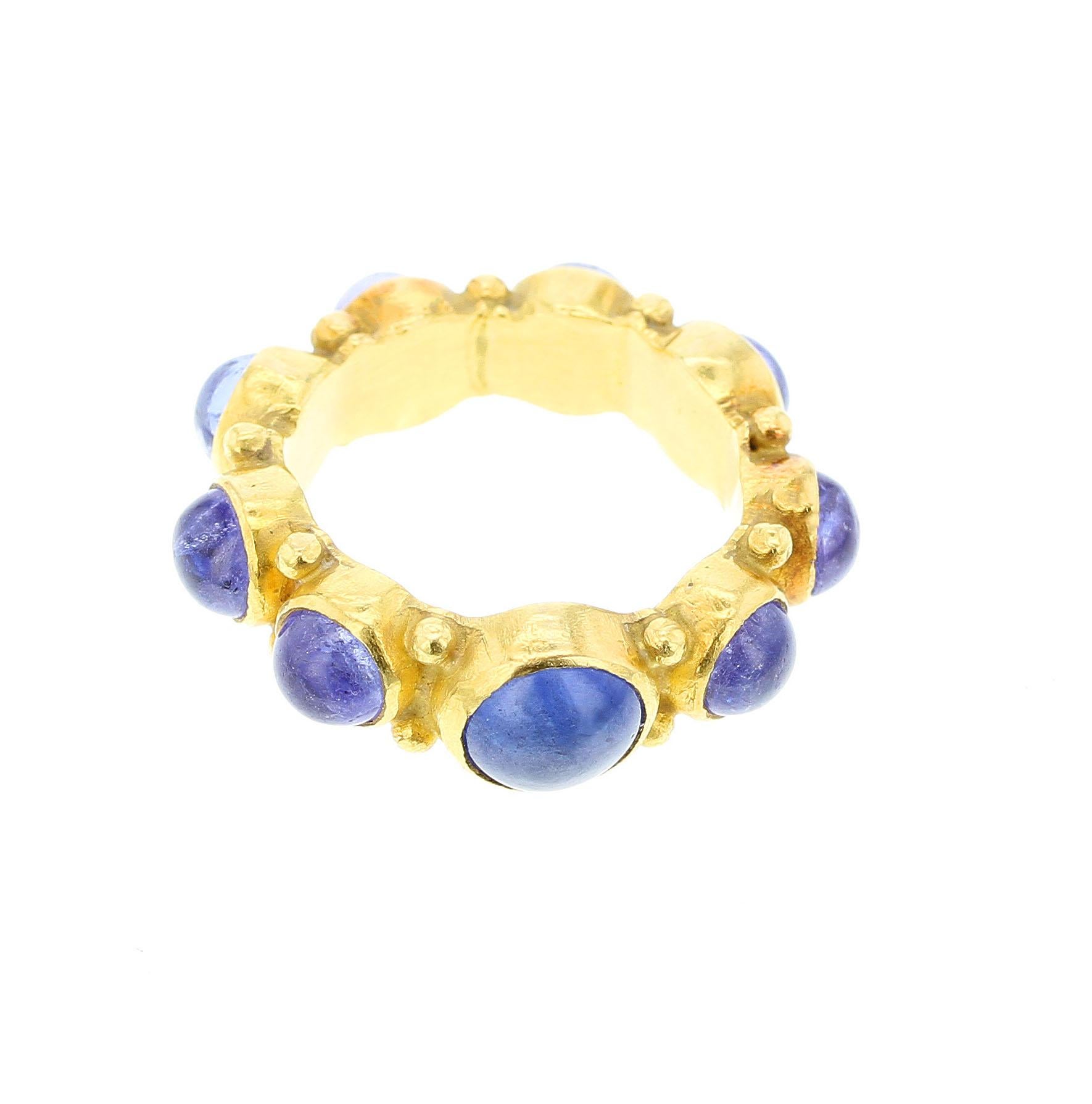 A beautiful eternity style ring with one large blue sapphire cabochon (6.5MM), surrounded by 8 blue sapphire cabochons (4.5-5MM) circling the shank with gold beads accented in between. Ring Size US 5.75. Matte finish. 