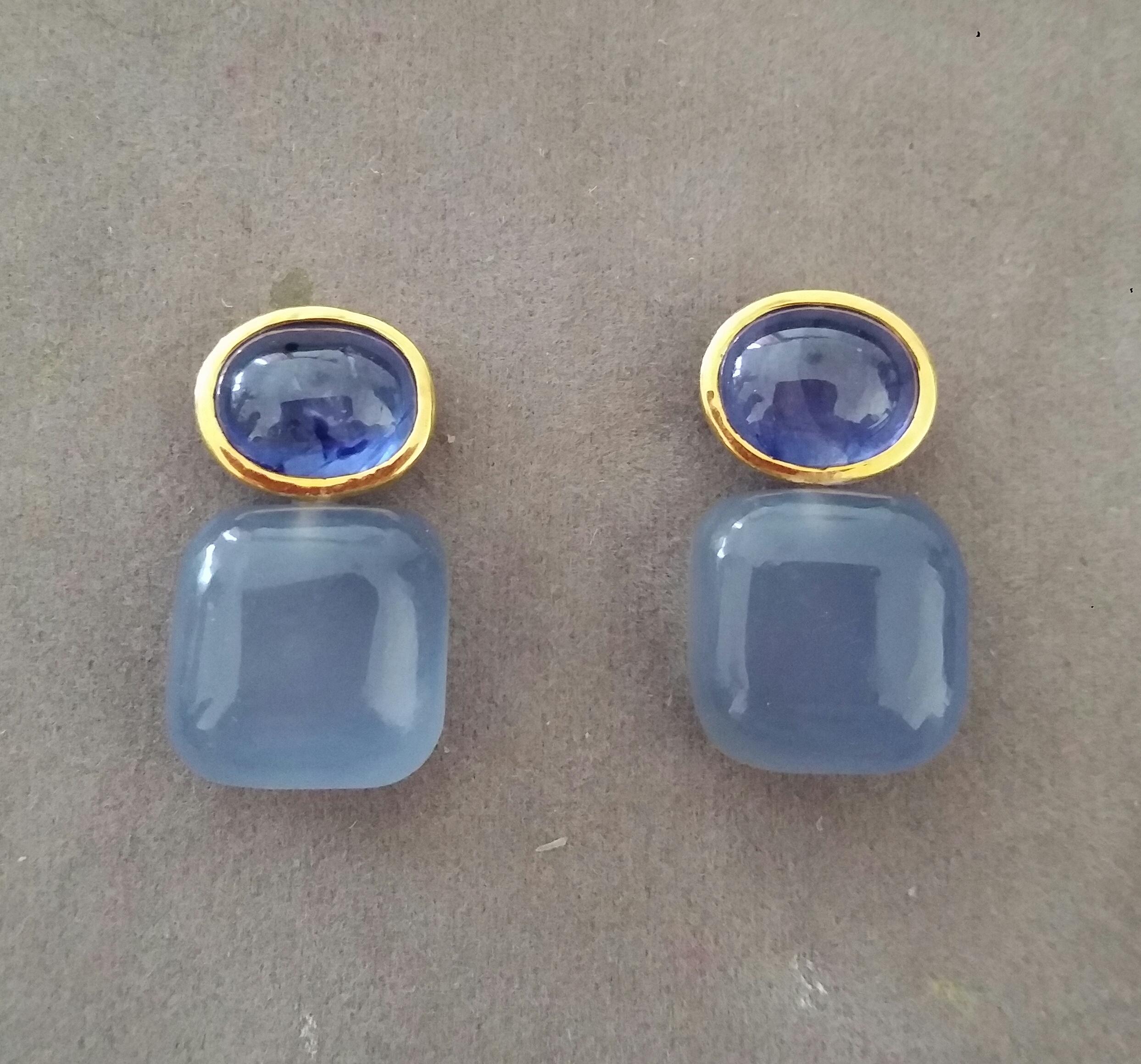 These simple but elegant and handmade earrings have 2 Oval  Blue Sapphire cabs measuring 8 x 10 mm set in a 14 Kt yellow gold bezel  at the top to which are suspended 2  Cushion Shape Blue Chalcedony  measuring 14 x 14 mm.

In 1978 our workshop