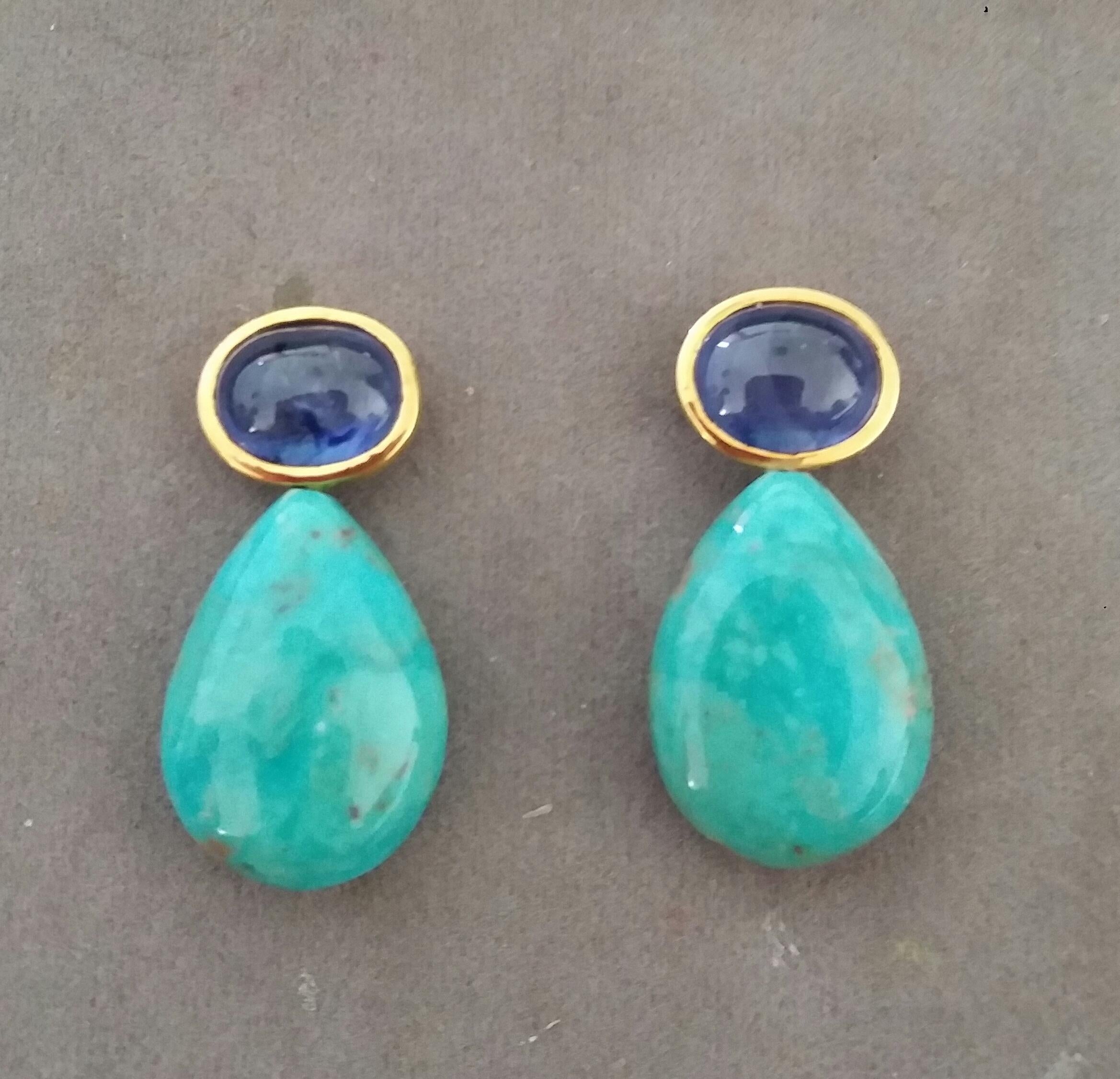 These simple but elegant and handmade earrings have 2 Oval  Blue Sapphire cabs measuring 8 x 10 mm set in a 14 Kt yellow gold bezel  at the top to which are suspended 2 Plain Natural Turquoise  Drops measuring 15 x 21 mm.

In 1978 our workshop