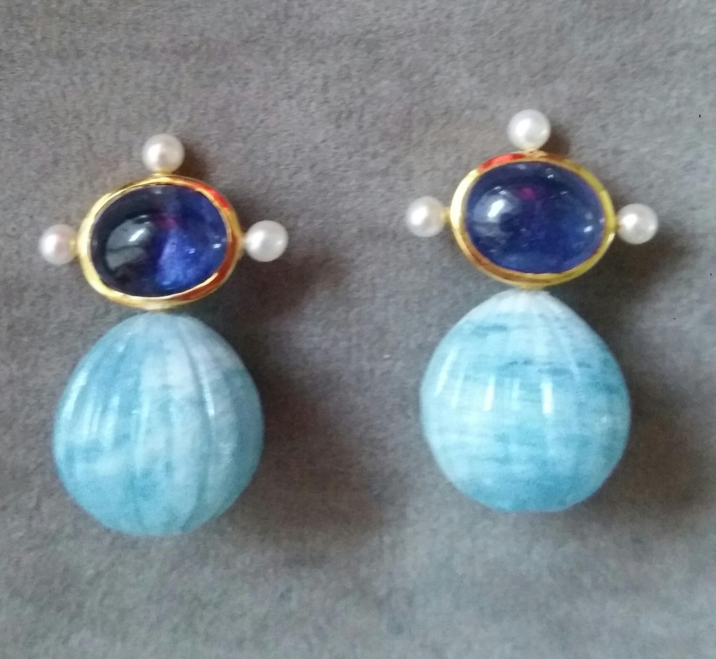 These elegant and handmade earrings have 2 Oval  Blue Sapphire cabs measuring 8 x 10 mm set in a 14 Kt yellow gold bezel with 3 small round pearls of 4mm on 3 sides at the top to which are suspended 2 Engraved  Aquamarine Round Drops measuring 15 x