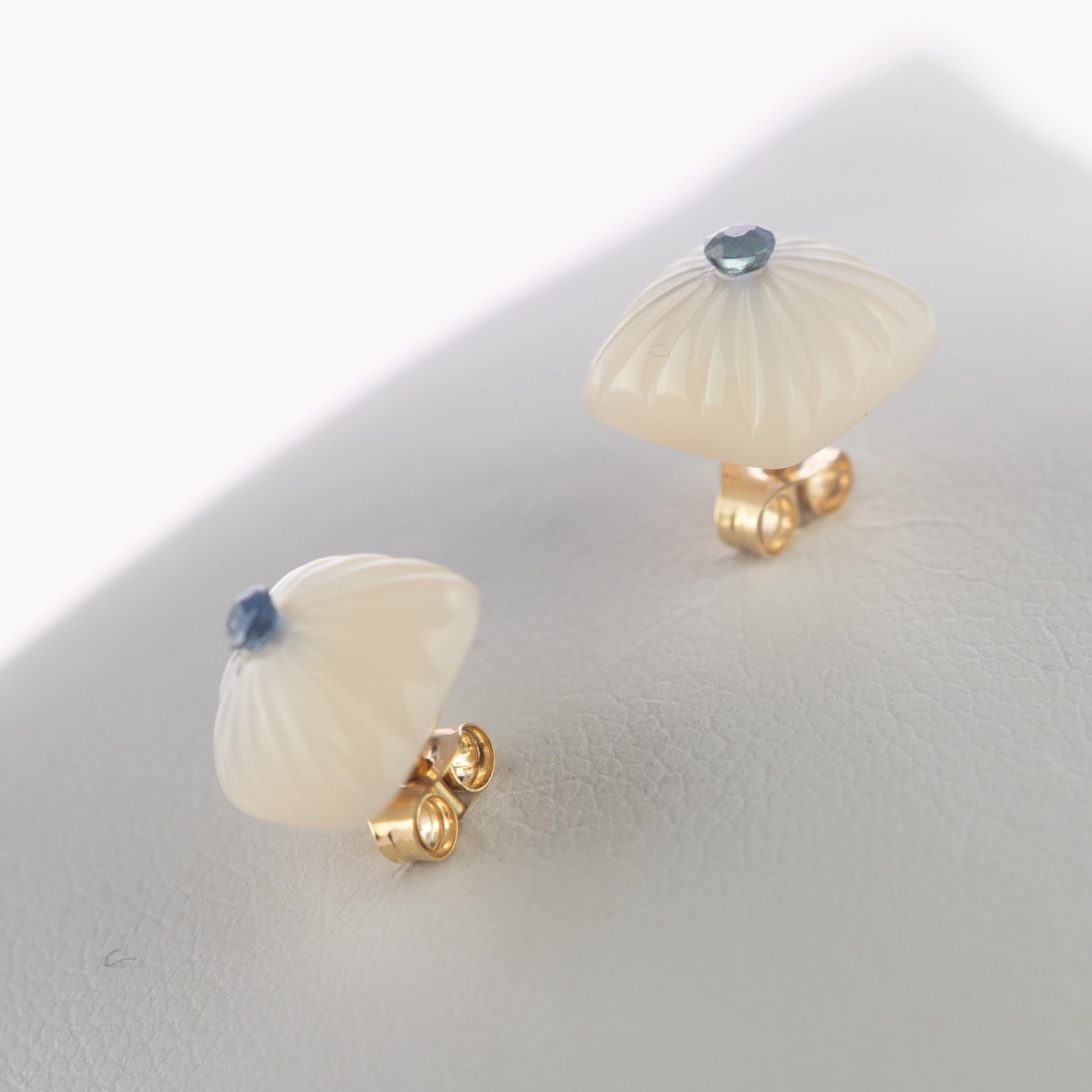 Wunderschöne geschnitzte quadratische Ohrstecker. 2.5 Karat natürlicher Perlmutt-Cabochon, verziert mit einer zarten blauen Saphirperle in der Mitte. Mit einer einzigartigen Schnitzerei von Linien geformt, die von der Mitte kommen, um das Ende des