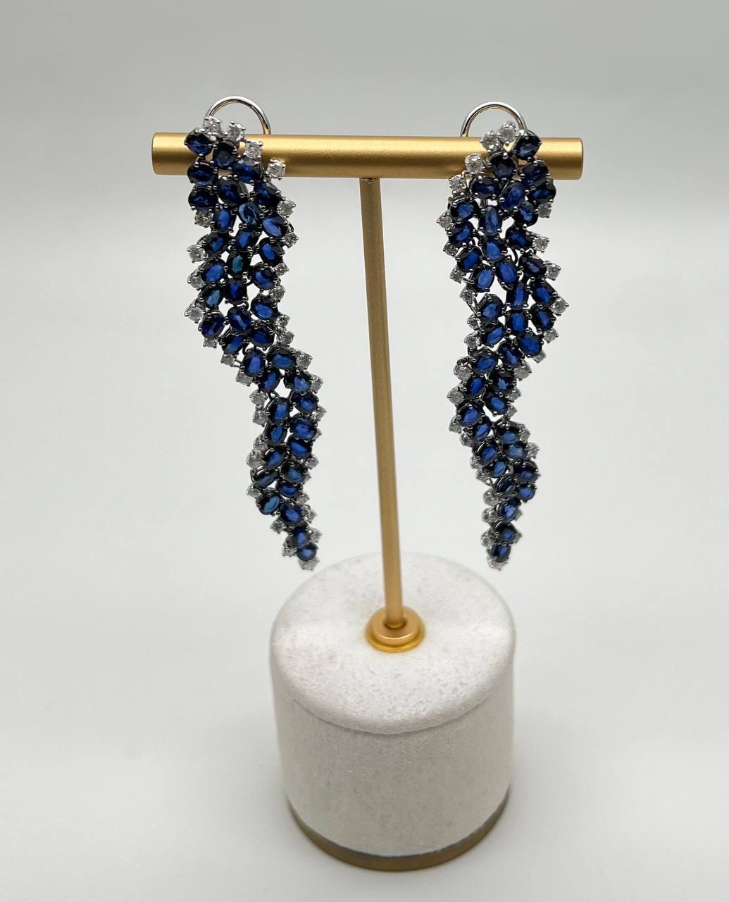 Entdecken Sie die Eleganz dieser exquisiten Ohrringe.

Diese Ohrringe sind mit einer Kaskade tiefblauer Saphire besetzt und sorgen für einen auffallenden optischen Effekt. Jedes Stück ist sorgfältig in 18 Karat Weißgold gefasst, was den satten