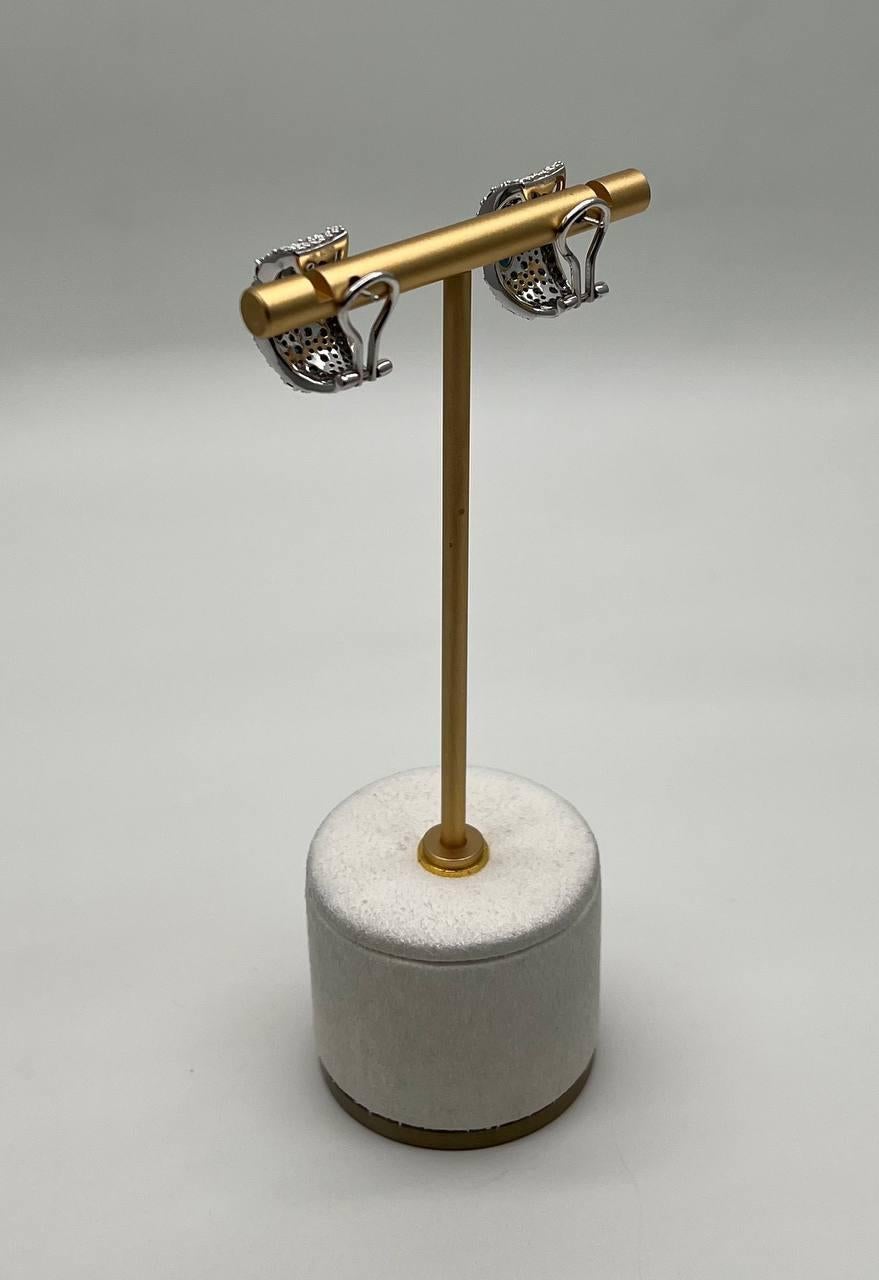 Questi straordinari orecchini presentano un design audace e strutturato. I dettagli intricati con elementi scintillanti creano un effetto visivo accattivante. Un ornamento elegante e accattivante. Oro bianco 14K. 1,01 CTW Diamanti. 2,20 CTW Zaffiri