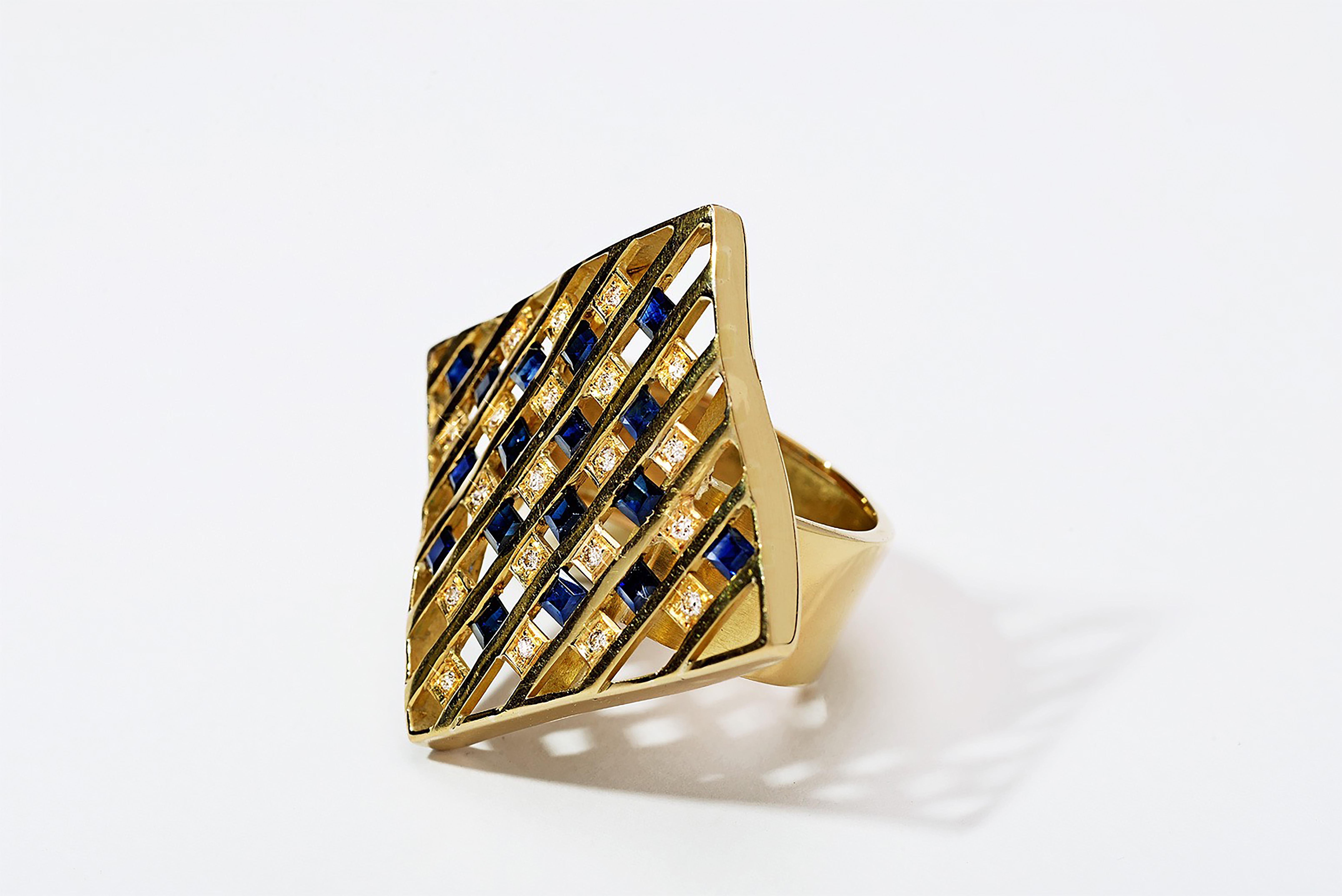 A one-of-a-kind treasure, crafted in 18k yellow gold and a combination of tension set princess-cut blue sapphire and bezel set diamonds. The rhombus shape extends loosely in fluidity with the hand's movement.

The Chao Kalfu ring is part of the