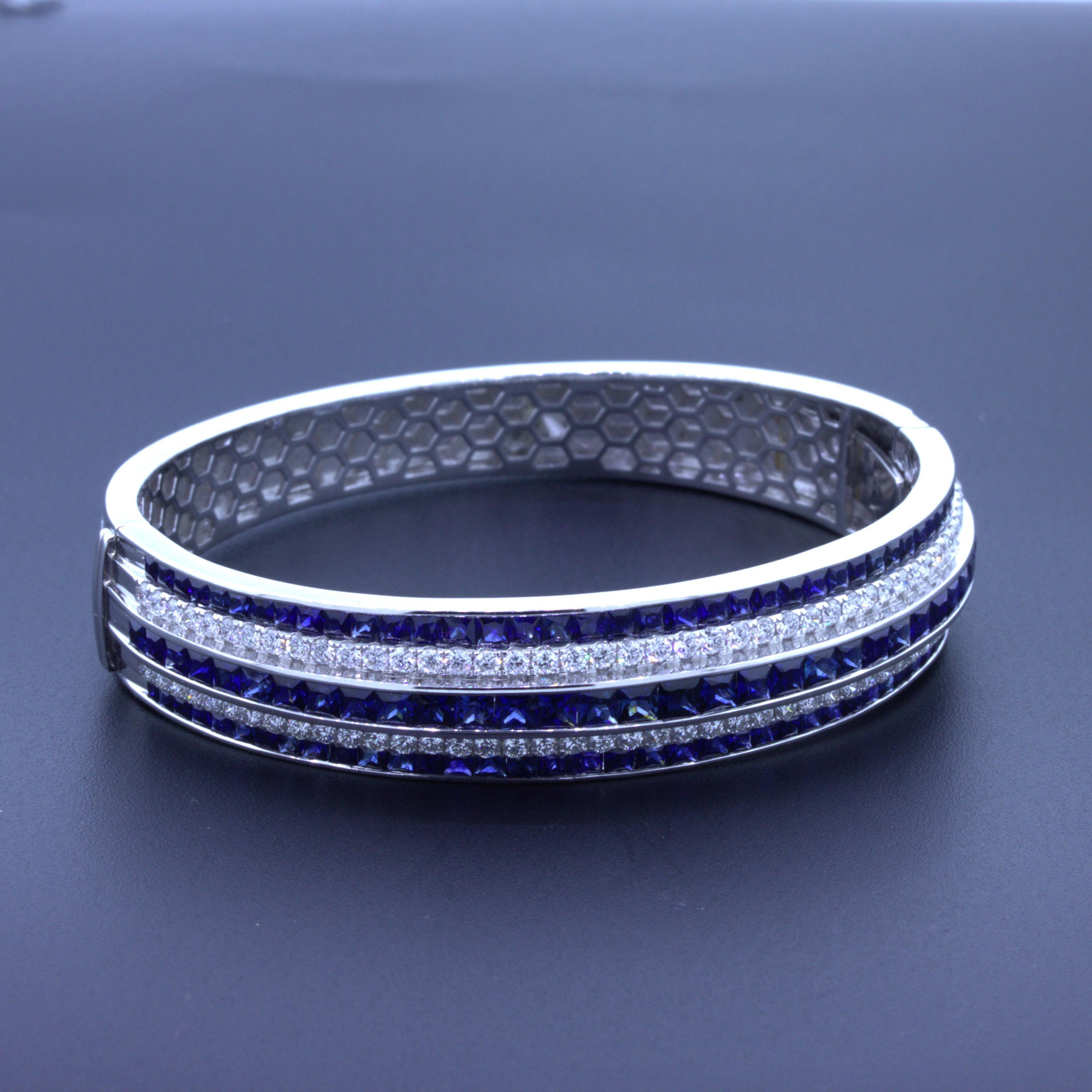 A chic and elegant 18k white gold bangle. It features 3 rows of square-shape blue sapphire weighing a total of 9.77 carats. They all have a rich royal blue color that radiates in the light. It is further accented by two rows of round brilliant-cut