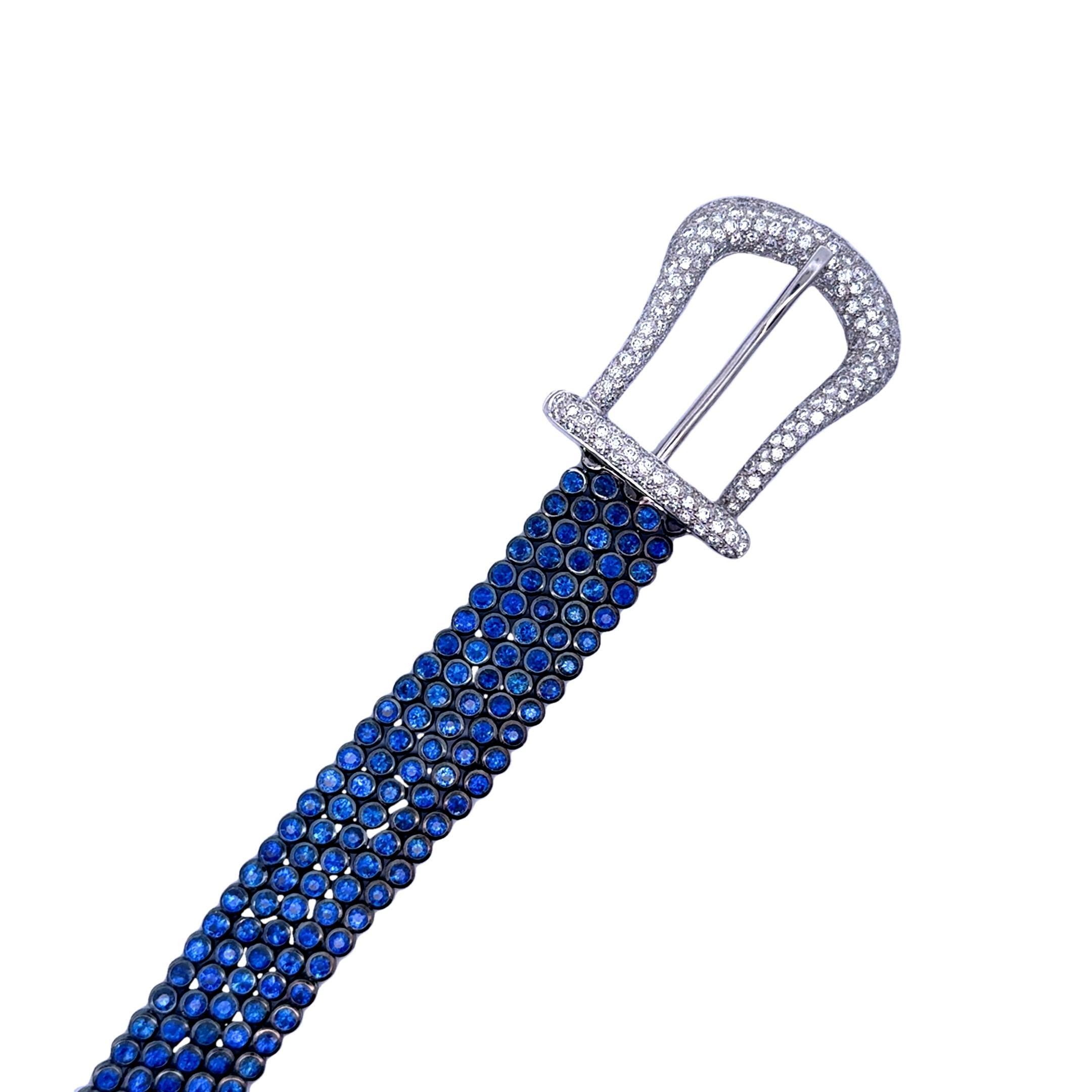 A striking contemporary belt buckle bracelet, encrusted with a dazzling array of blue sapphires and diamonds. The bracelet features approximately 35 carats of round-cut blue sapphires which are individually bezel-set giving it a sleek and luxurious