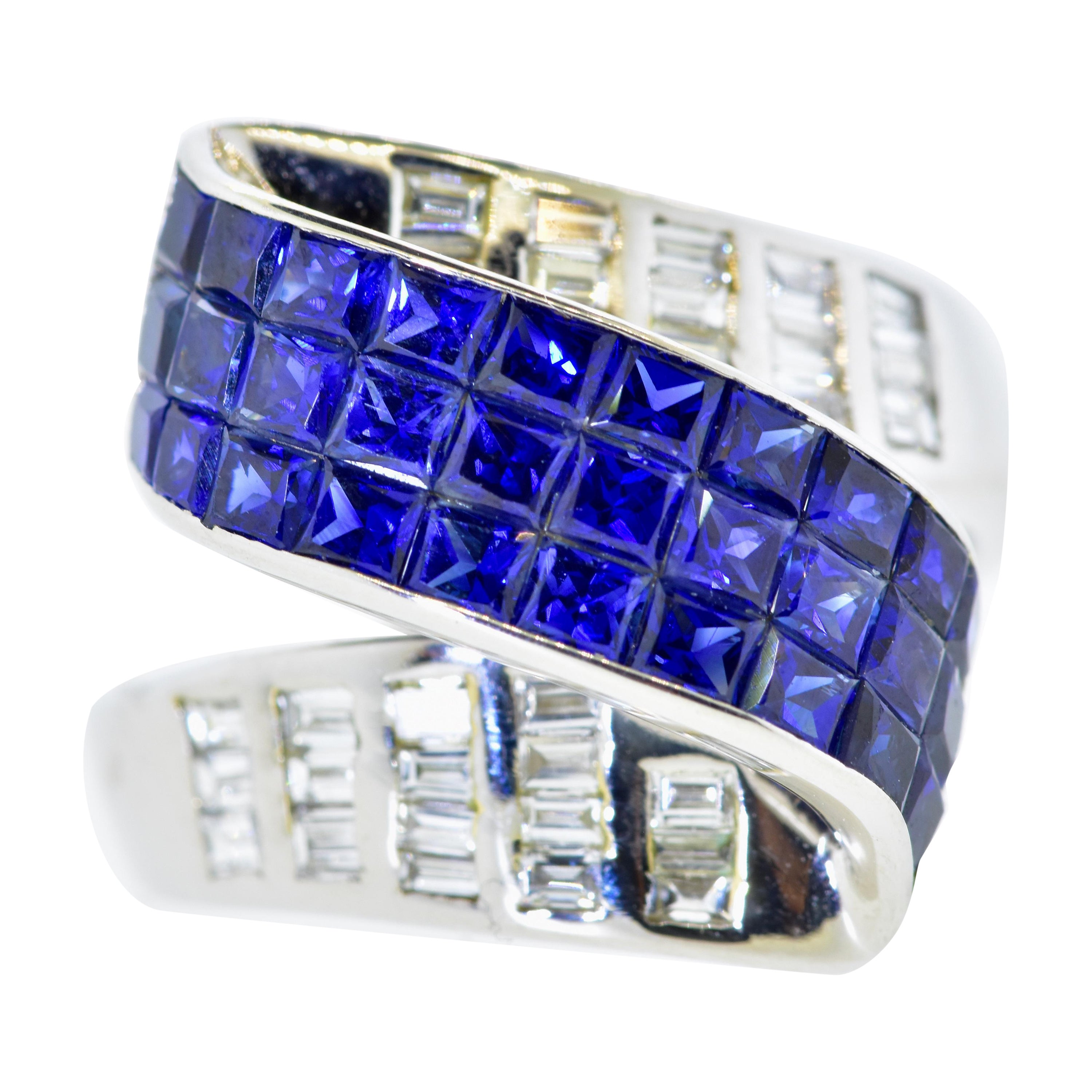Diamond and Sapphire Contemporary ring.  In a scroll like motif, this unusual and finely made ring possesses invisibly set (one cannot set the metal between the sapphires)  natural vivid royal blue sapphires   The weight of these sapphires is