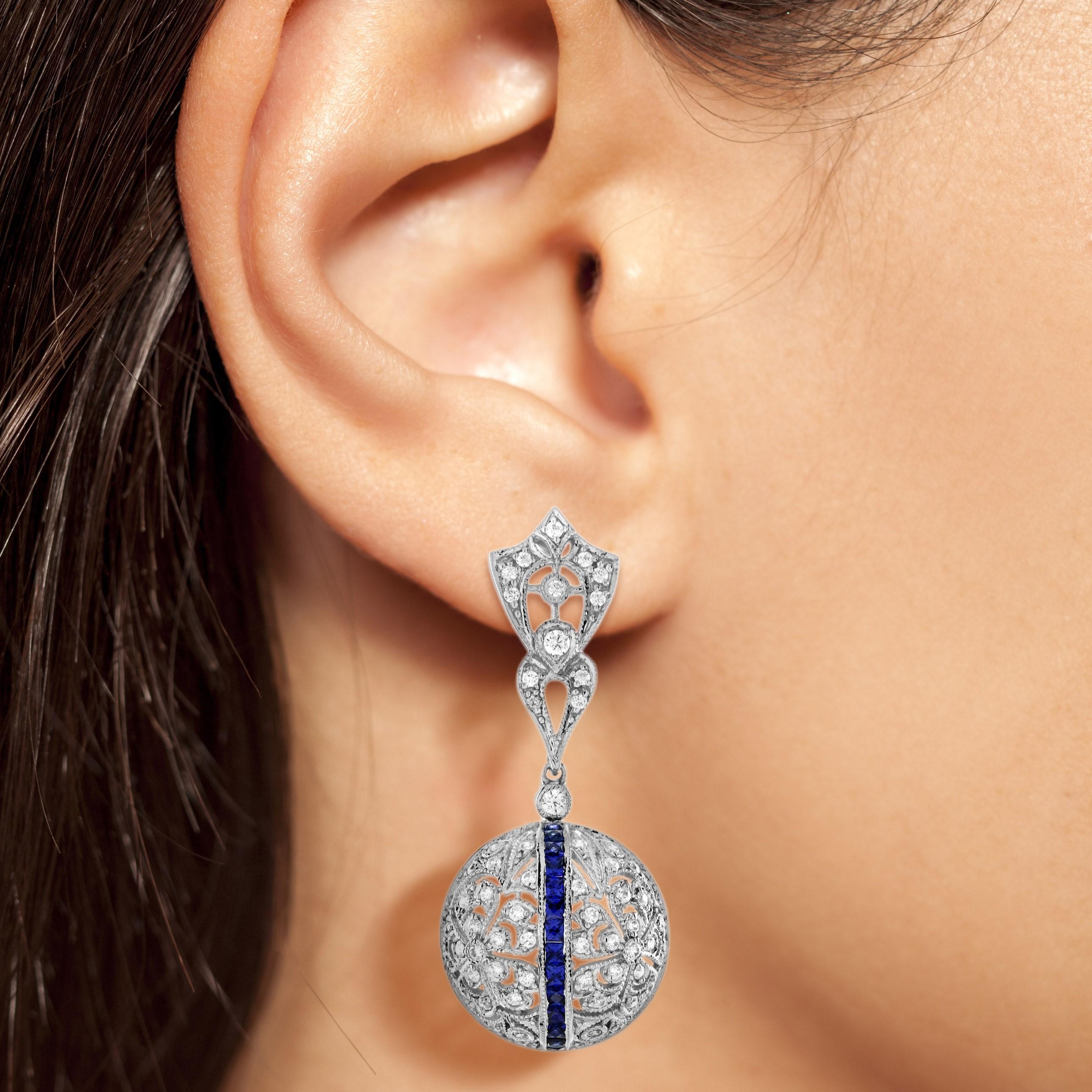 Diese Ohrringe mit blauem Saphir und Diamant im Art-Déco-Stil aus 14 Karat Weißgold machen jeden Moment zu etwas ganz Besonderem. Die sattblauen Saphire bilden zusammen mit den strahlenden Diamanten einen schillernden Kontrast, der bei jeder