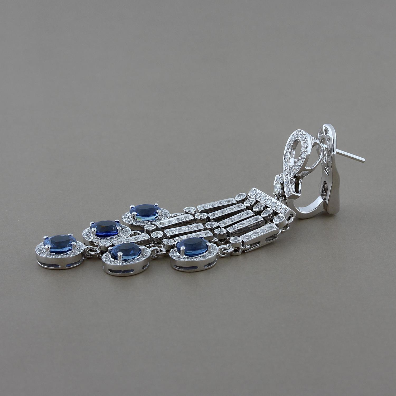 Eleganza sofisticata! Questi orecchini presentano 5,43 carati di zaffiri blu di forma ovale accentuati da 2,09 carati di diamanti a taglio rotondo. Questi orecchini a goccia a lampadario sono incastonati in oro bianco 18 carati con chiusura a clip