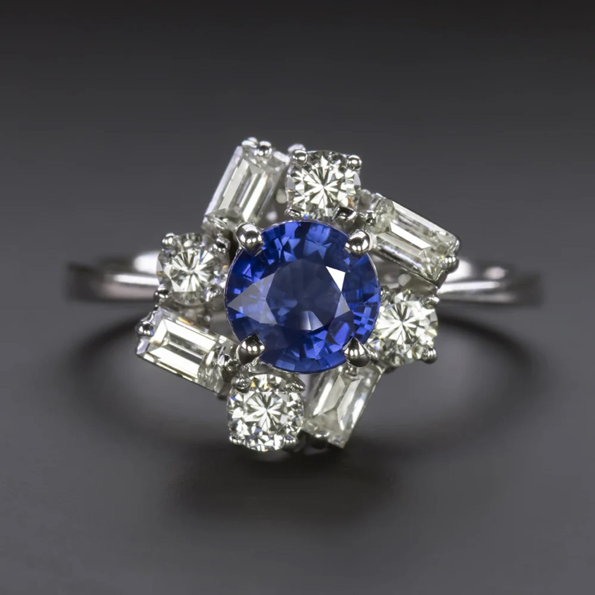 Presenting an exquisite cocktail ring showcasing a luxurious blue sapphire encircled by a distinctive tiered halo of round and baguette-cut diamonds.

Highlighted features include:

A captivating 0.88 carat natural sapphire center boasting a deeply