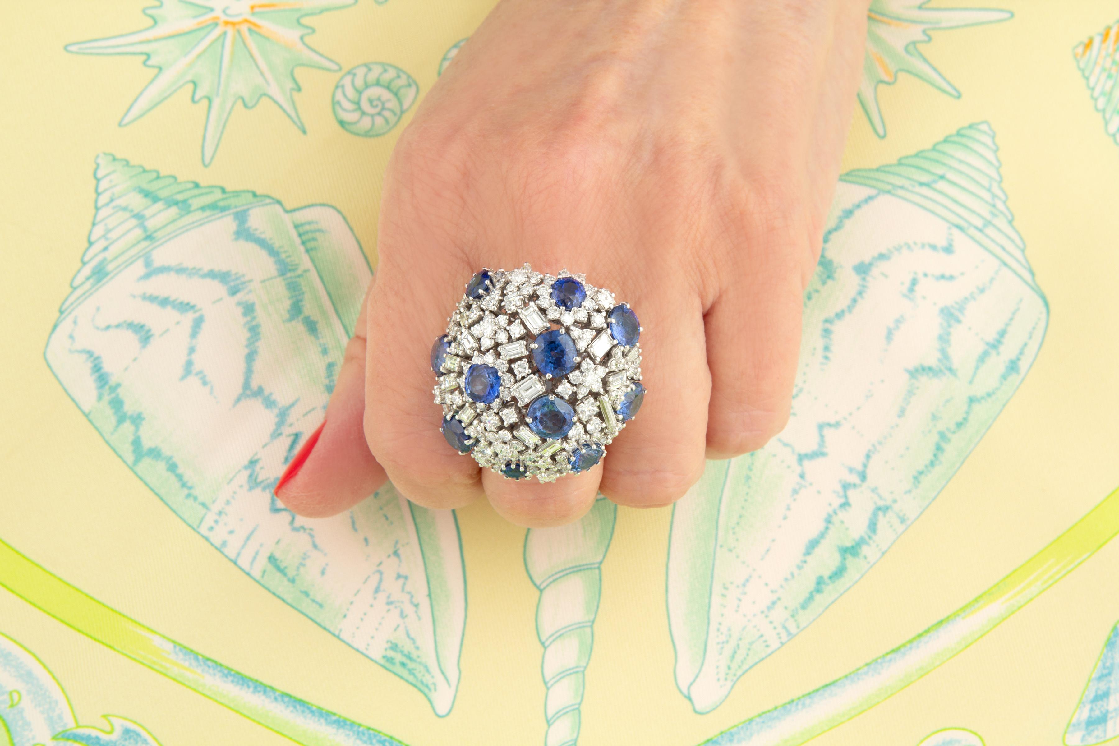 L'anello cocktail con zaffiro blu e diamante a cupola presenta 12,61 carati di zaffiri di Ceylon sfaccettati di qualità fine a taglio ovale. Gli zaffiri sono incastonati ad arte in un sofisticato design a cupola con 4,24 carati di diamanti rotondi e