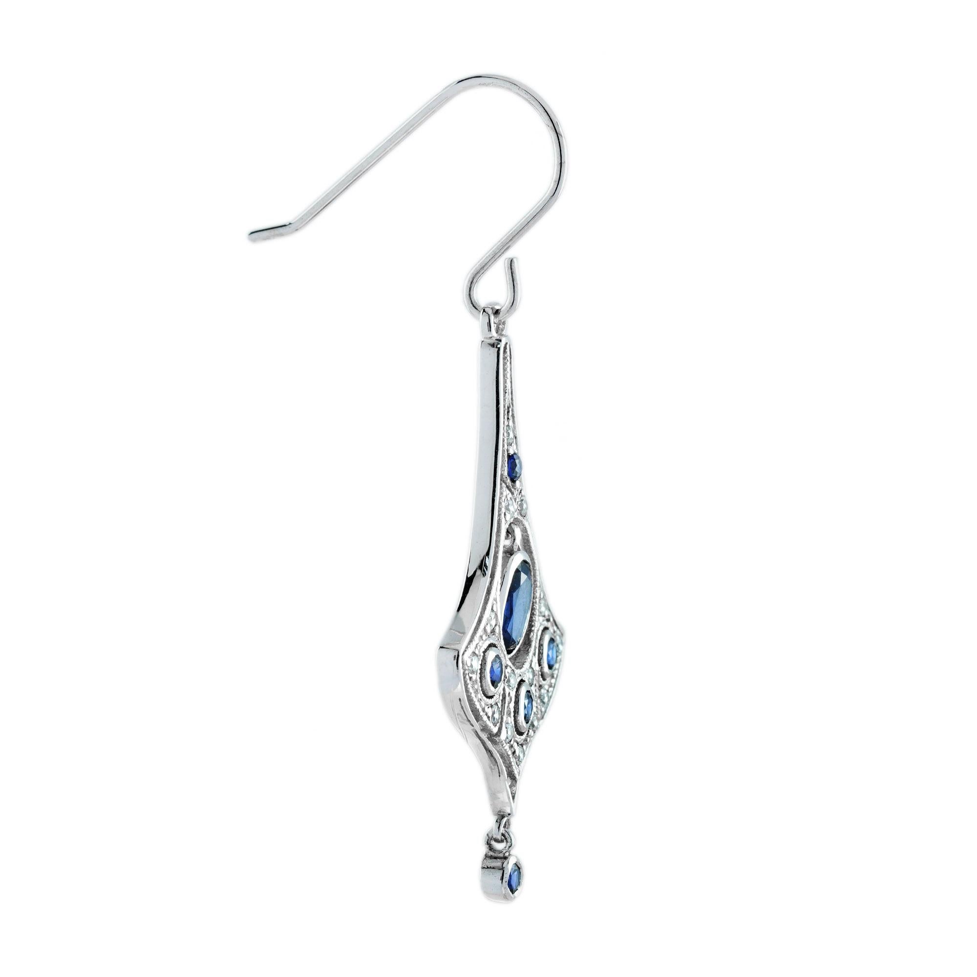 A very pretty pair of white gold blue sapphire and diamond drop earrings. They are composed of oval blue sapphires in the center with additional round sapphires and diamonds for their accent. The sapphires are very well matched royal blue color
