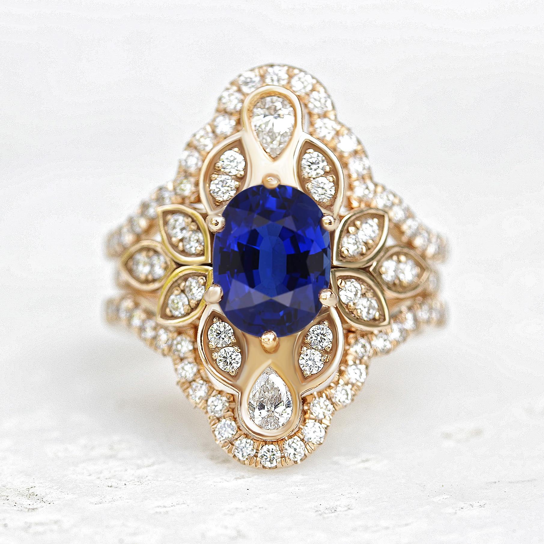 Dieser Verlobungsring besticht durch einen ovalen blauen Saphir - den traditionellen Geburtsstein des Monats September - in der Mitte, der mit Jugendstil-Blattornamenten und zwei birnenförmigen Diamanten verziert ist. Dieser königliche