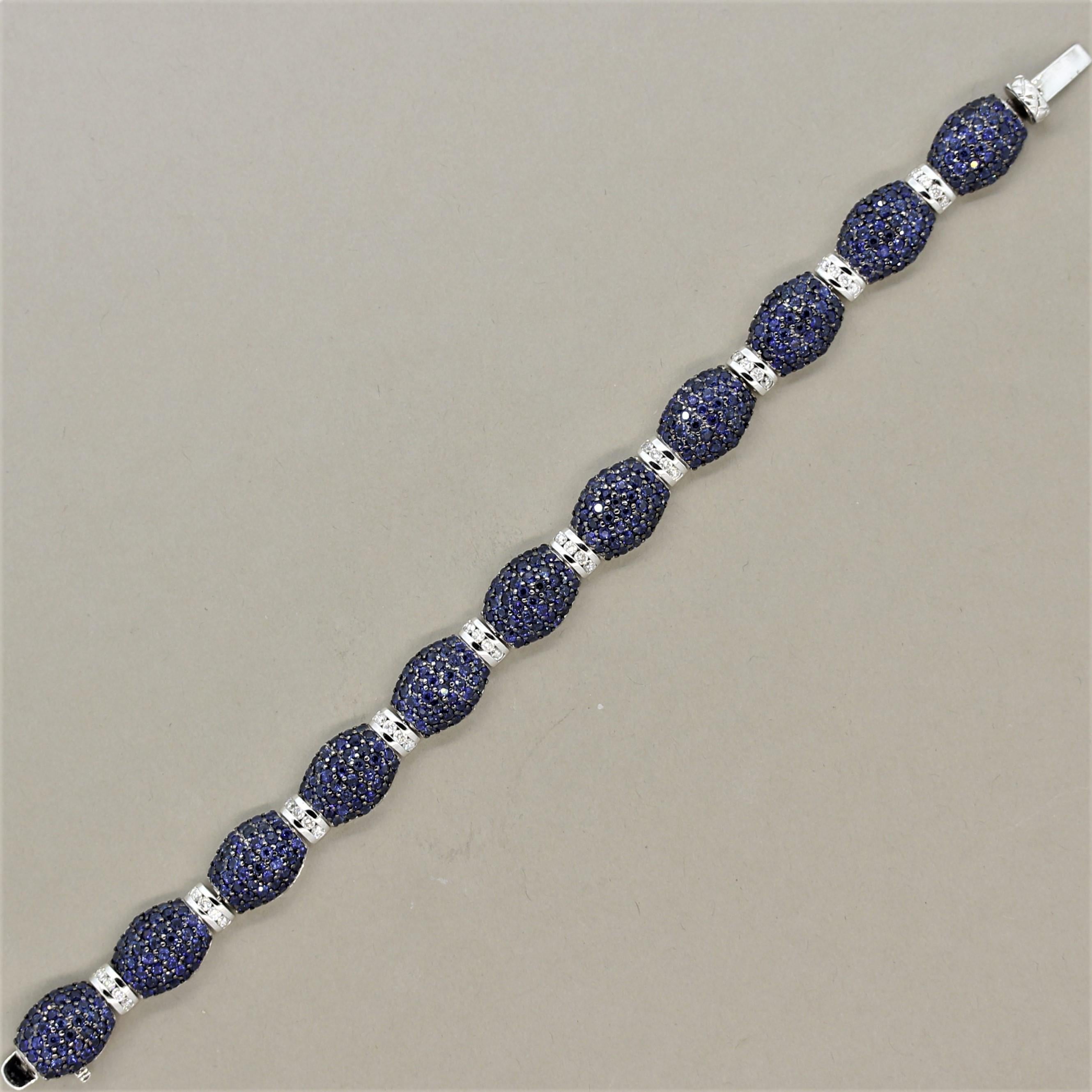 A unique styled bracelet featuring 21.30 carats of bright vivid blue sapphires! They are pave set over domed links of 18k gold with a rhodium finish over the prongs giving them a black appearance that contrasts with the bright blue sapphires. Adding