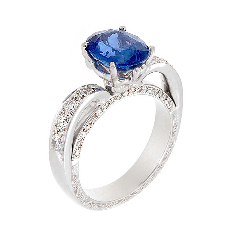 A ring fit for a queen! A 3.00 carat oval blue sapphire ring set in an 18K white gold crown like setting. The beautiful ocean blue sapphire is adorned by 0.72 carats of round diamonds along the royal setting. 

Currently ring size 6