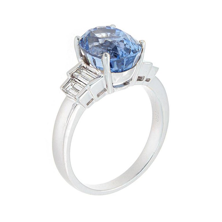 Simply elegant.  A sparkling 5.41 carat oval cut blue sapphire is accented by 0.51 carats of VVS quality baguette cut diamonds, all set in 18K white gold.  

Currently ring size 6.75