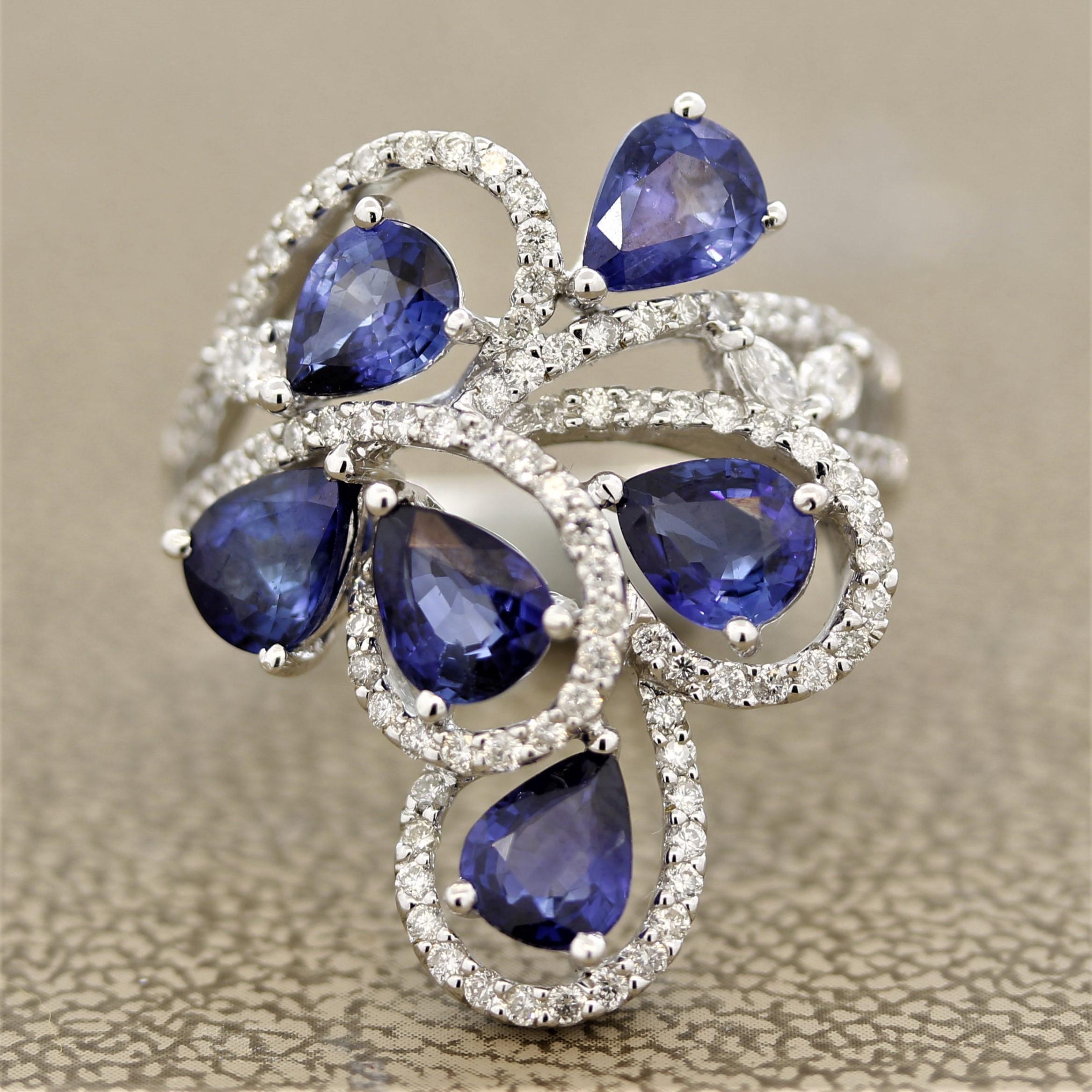 A sweet and stylish white gold ring! It features 6 pear shaped sapphires weighing a total of 3.75 carats which has a bright and vibrant blue color. They are accented by 0.81 carats of round brilliant and marquise shaped diamond. Made in 18k white