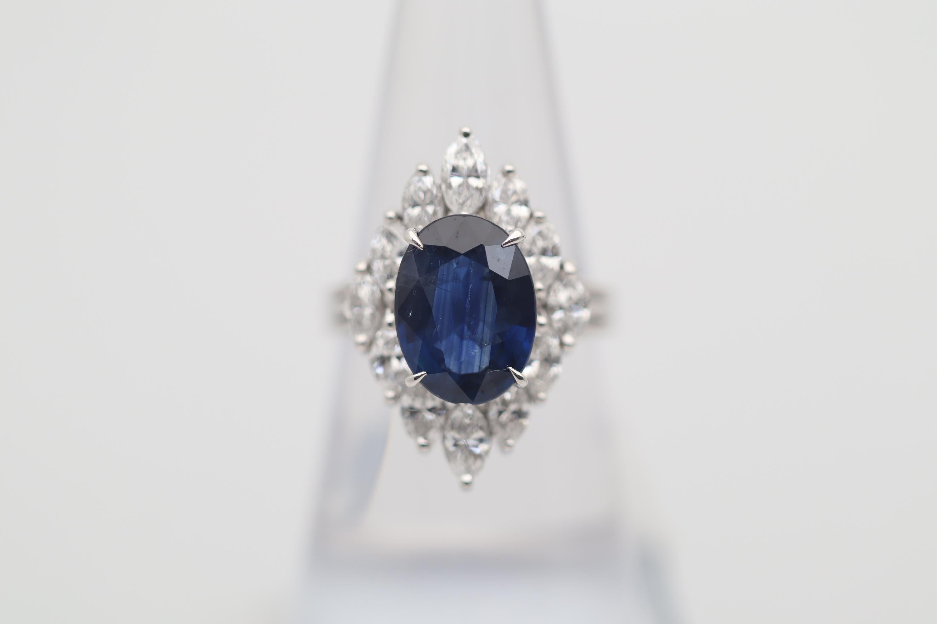 A fun, stylish and chic ring featuring a 4.77 carat natural blue sapphire! It has a lovely oval shape along with a rich blue color. It is accented by 1.68 carats of large marquise shape diamonds which are set around the sapphire giving the ring a