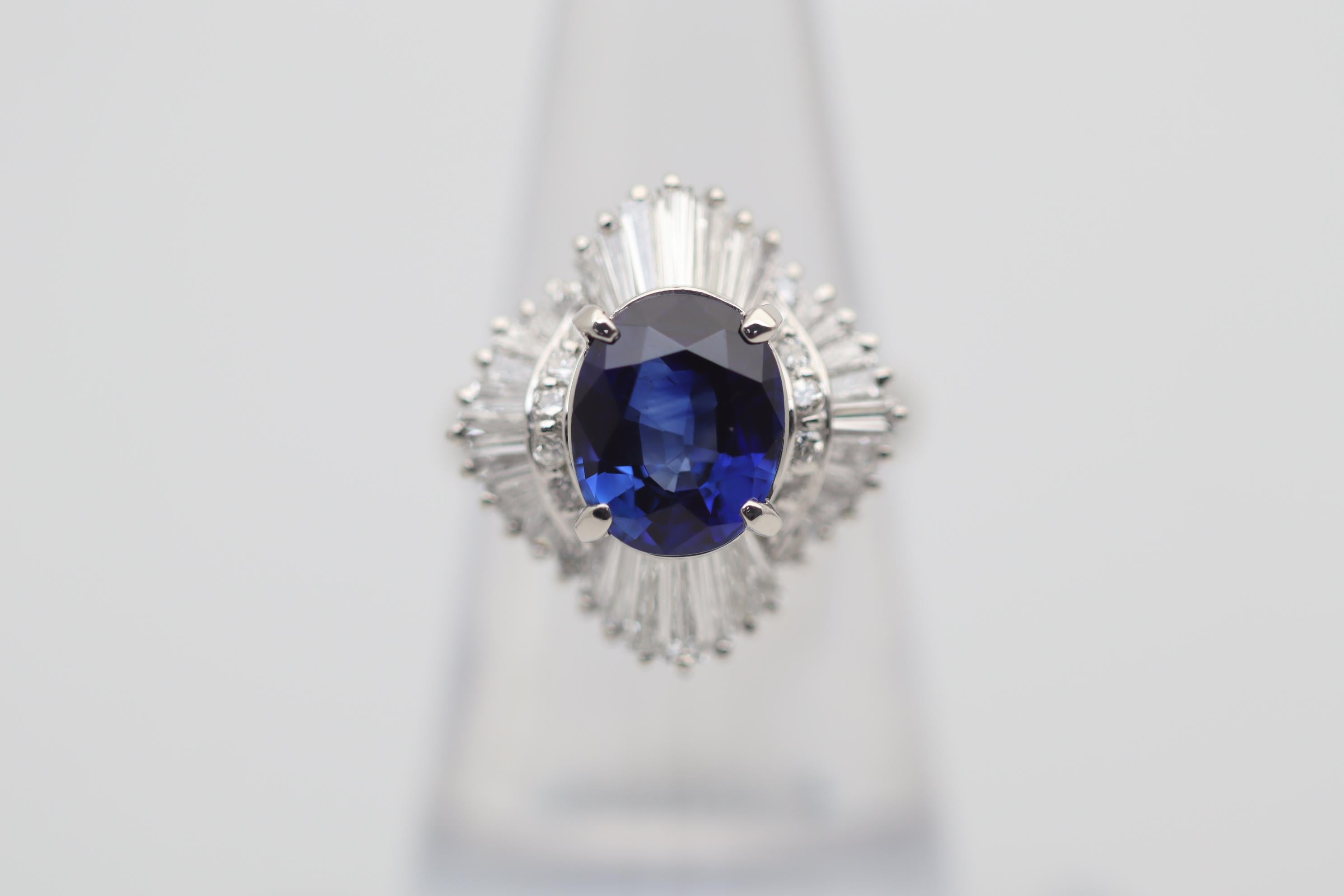 A lovely gem sapphire with a rich and intense blue color takes center stage. It weighs 3.16 carats and has excellent clarity allowing the stone's natural fine color to shine. It is complemented by 1.14 carats of round brilliant and baguette-cut