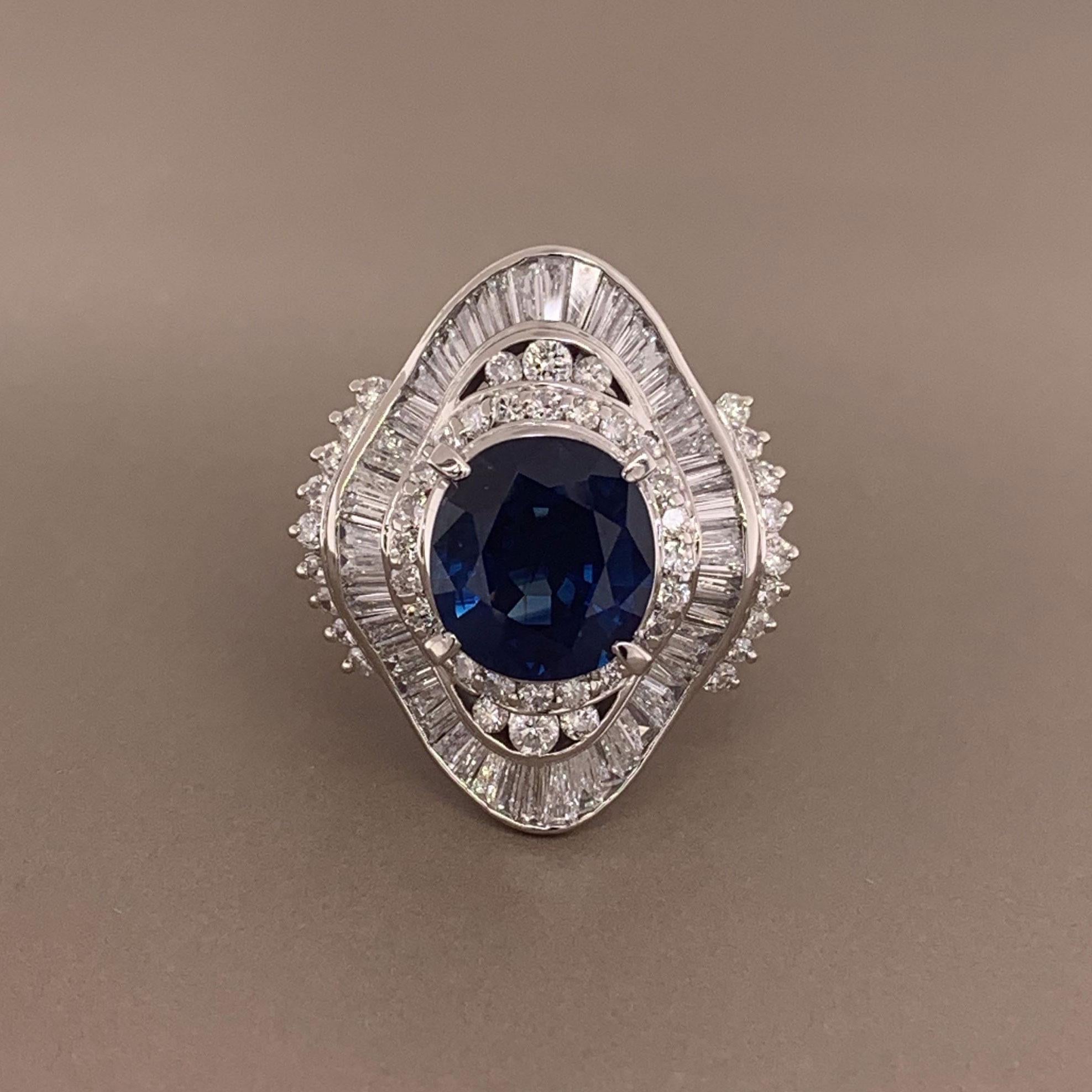 A ring hand fabricated in platinum. This special piece features a 3.71 carat oval shaped blue sapphire. It has a delicate blue color which is free from any inclusions. It is surrounded by1.55 carats of round and baguette cut diamonds which are set
