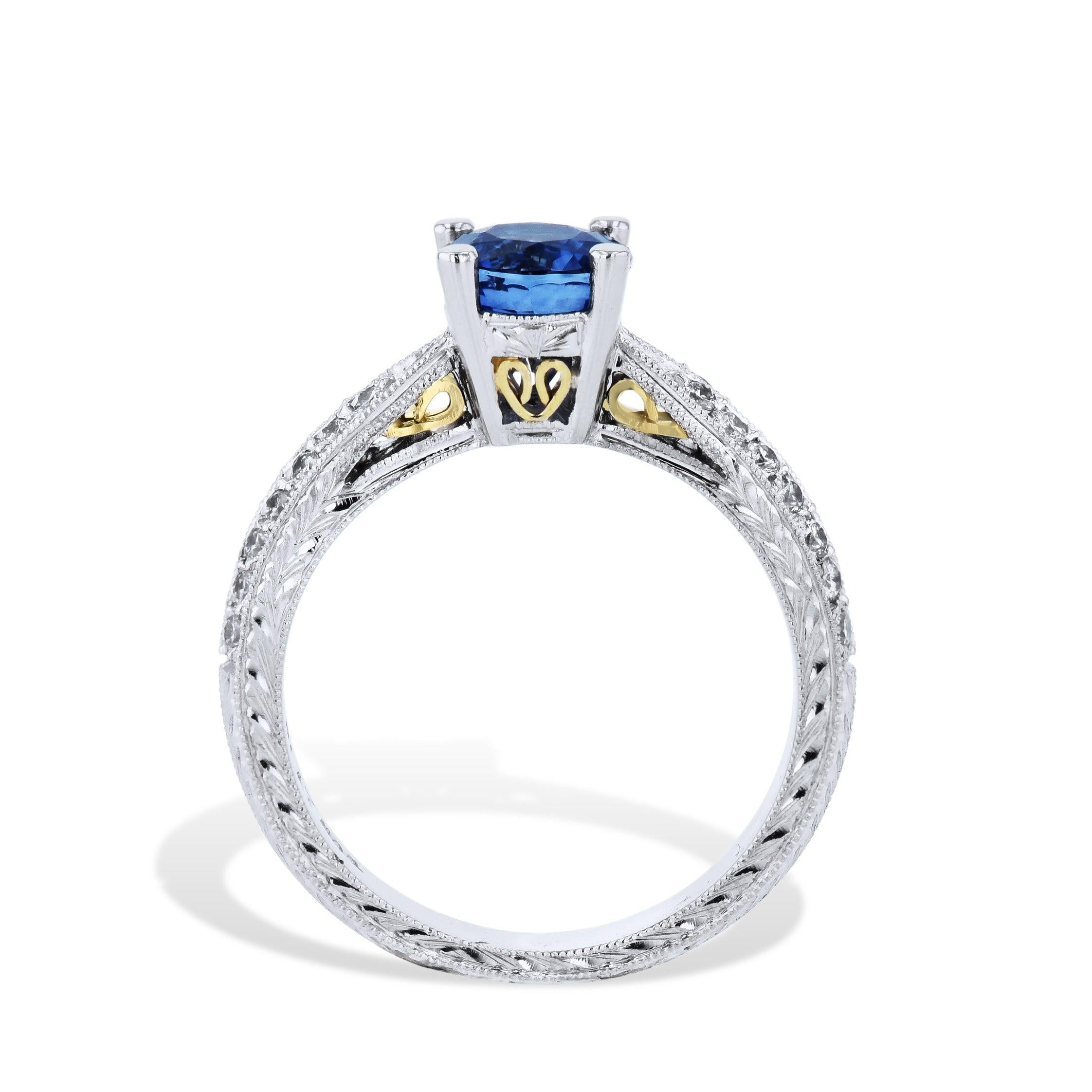 This breathtaking Blue Sapphire Diamond Estate Ring is crafted to perfection. It features a stunning round prong-set blue sapphire center stone, surrounded by 28 scintillating diamonds. A double row of pave diamonds and 18kt yellow gold filigree
