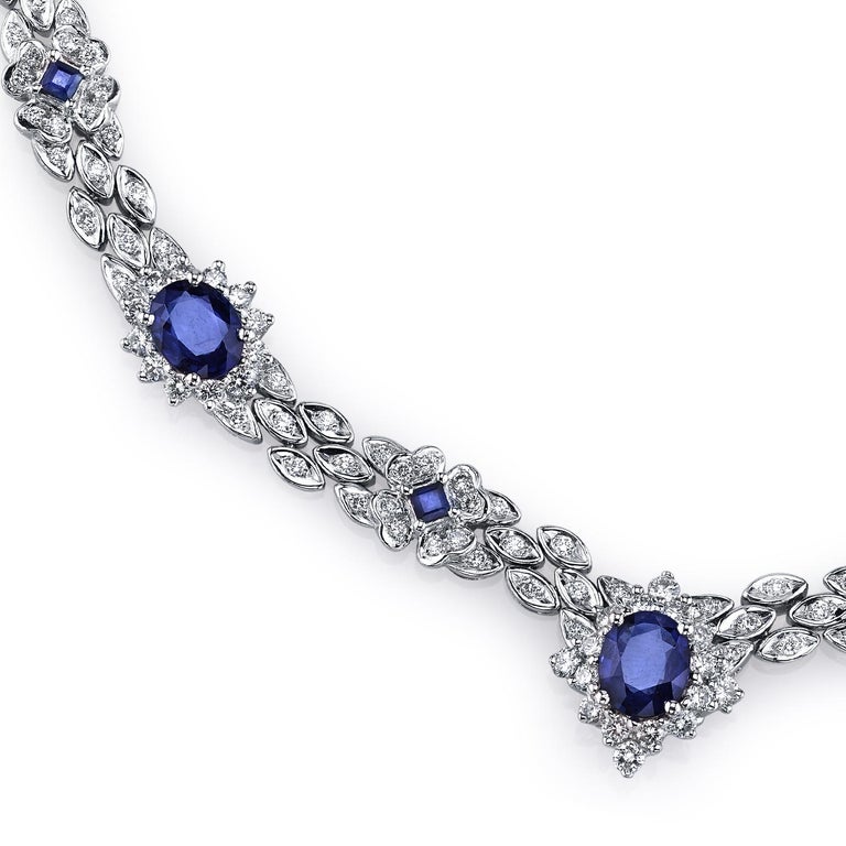 A dazzling necklace featuring 6.48 carats of vivid blue sapphires. The oval and princess cut blue sapphires form flower clusters as they are complemented by 5.86 carats of VS quality full-cut diamonds. Set in platinum.

Necklace Length: 16 1/4