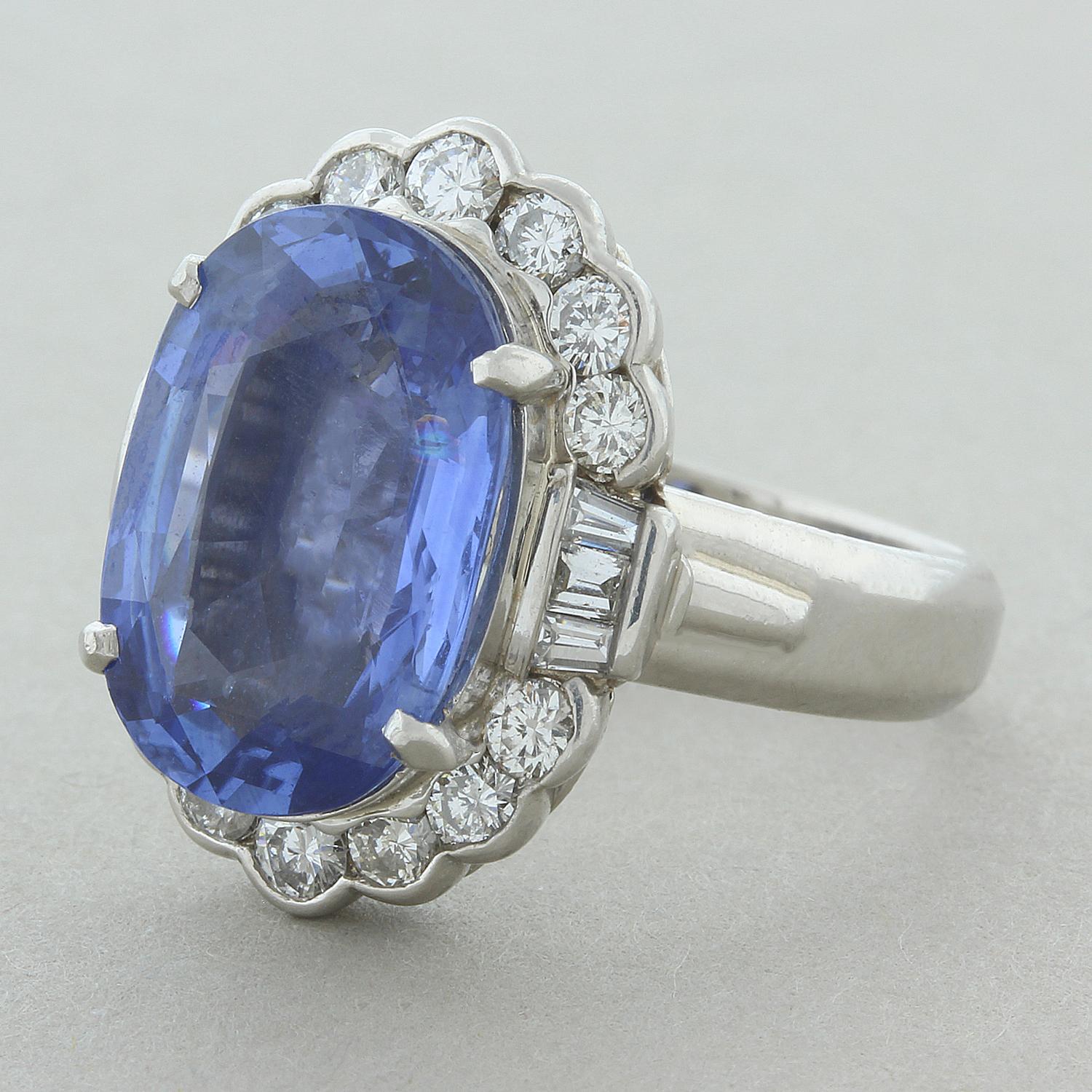 An elegant estate ring featuring a 7.38 carat gem quality luscious blue sapphire. The beautifully shaped oval cut sapphire is haloed by 0.88 carats of sparkling colorless round cut diamonds with three baguette cut diamonds on each side creating a
